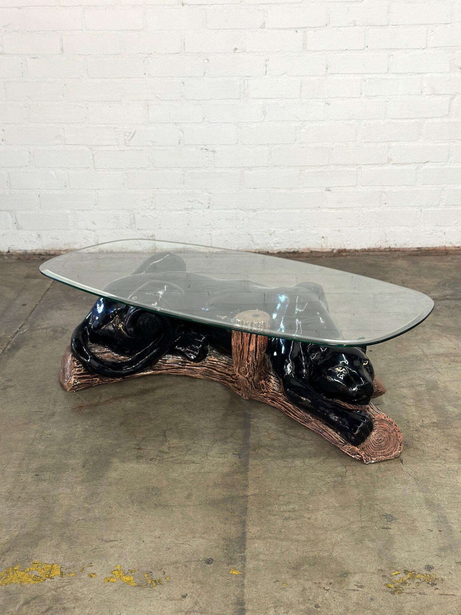 W52 D26 H15

Post Modern Panther Coffee Table. Featuring a black panther made from ceramic with a glass oval top. Table has some areas of wear that have been pictured.


