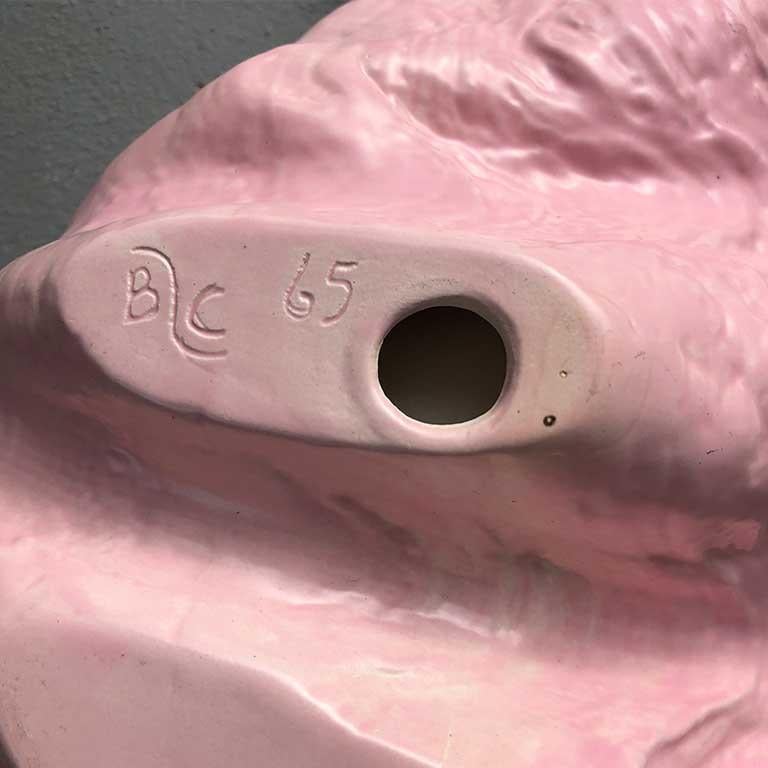 Large ceramic grotto-style clamshell with pink outer glaze and pearl white cream glaze on the inside. 

This ceramic clamshell has a beautiful shape. That outside is formed beautifully with ridges surrounding the outer portion of the piece. One side