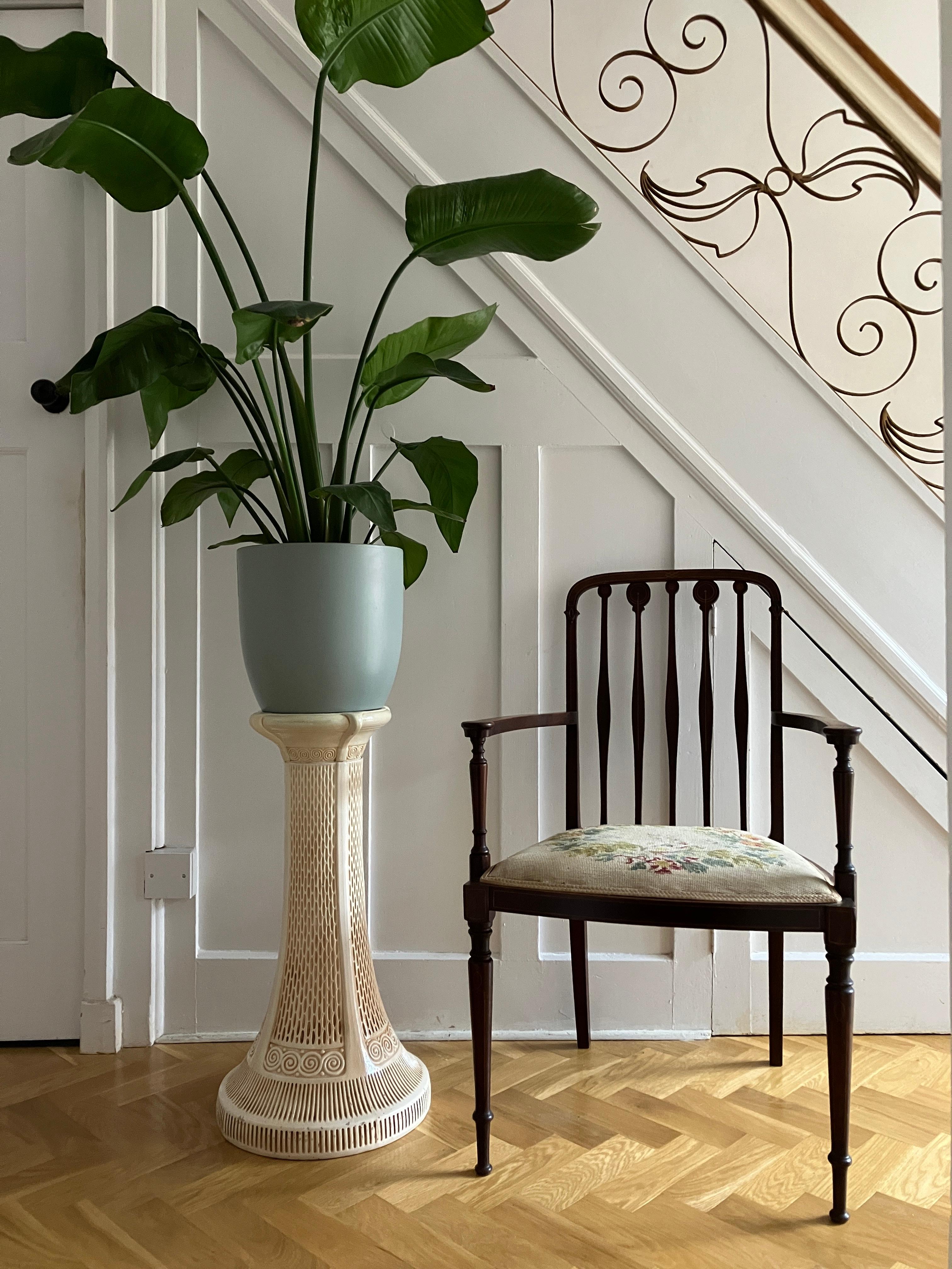 A beautiful bohemian ceramic plinth with an elegant design. The pedestal stand features an elegant embossed design with swirling borders in a cream with brown underplayed glaze. The vintage plinth would look amazing as a plant stand. Printed with