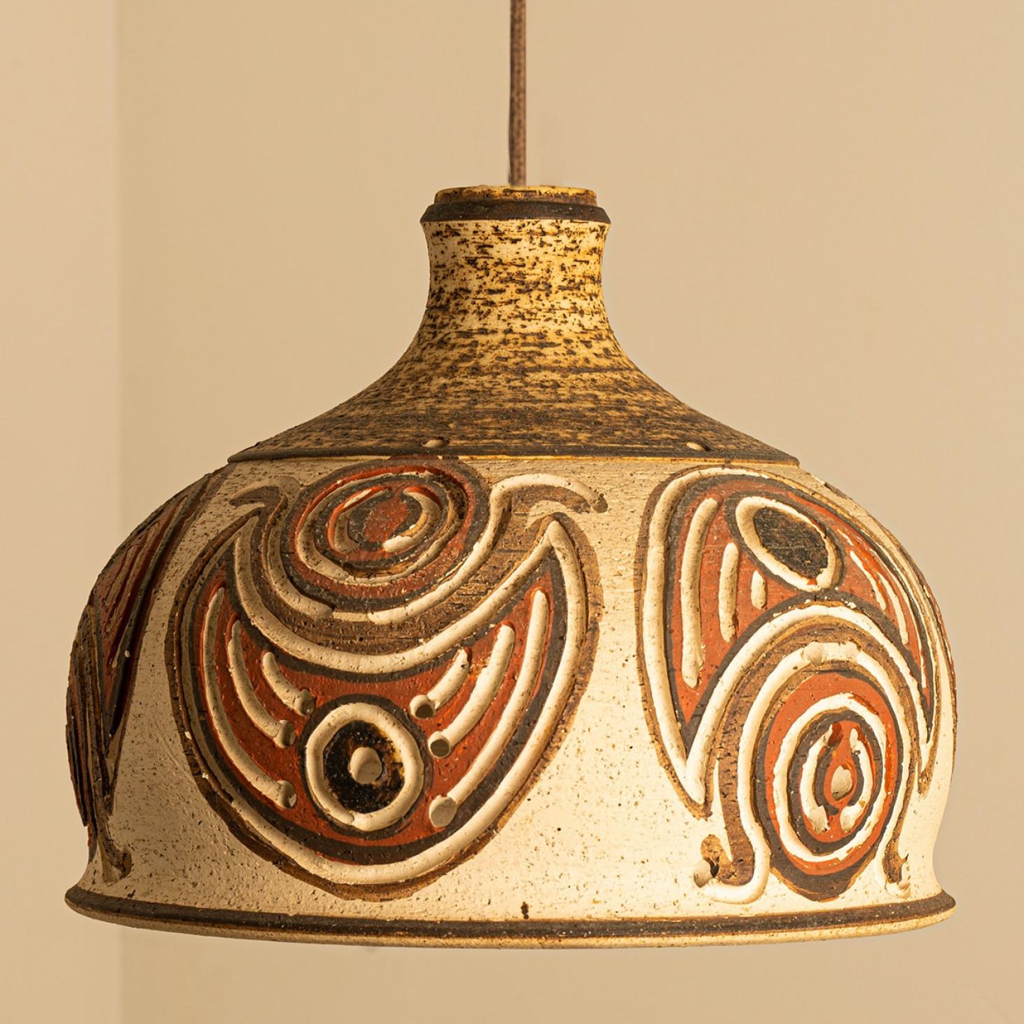 Stylish ceramic pendant light made in Denmark. The lamp is made of orange, brown and beige ceramics and has holes in it, illuminates beautifully.

Can be delivered with different cords and ceiling cups, see pictures for more options.

A unique
