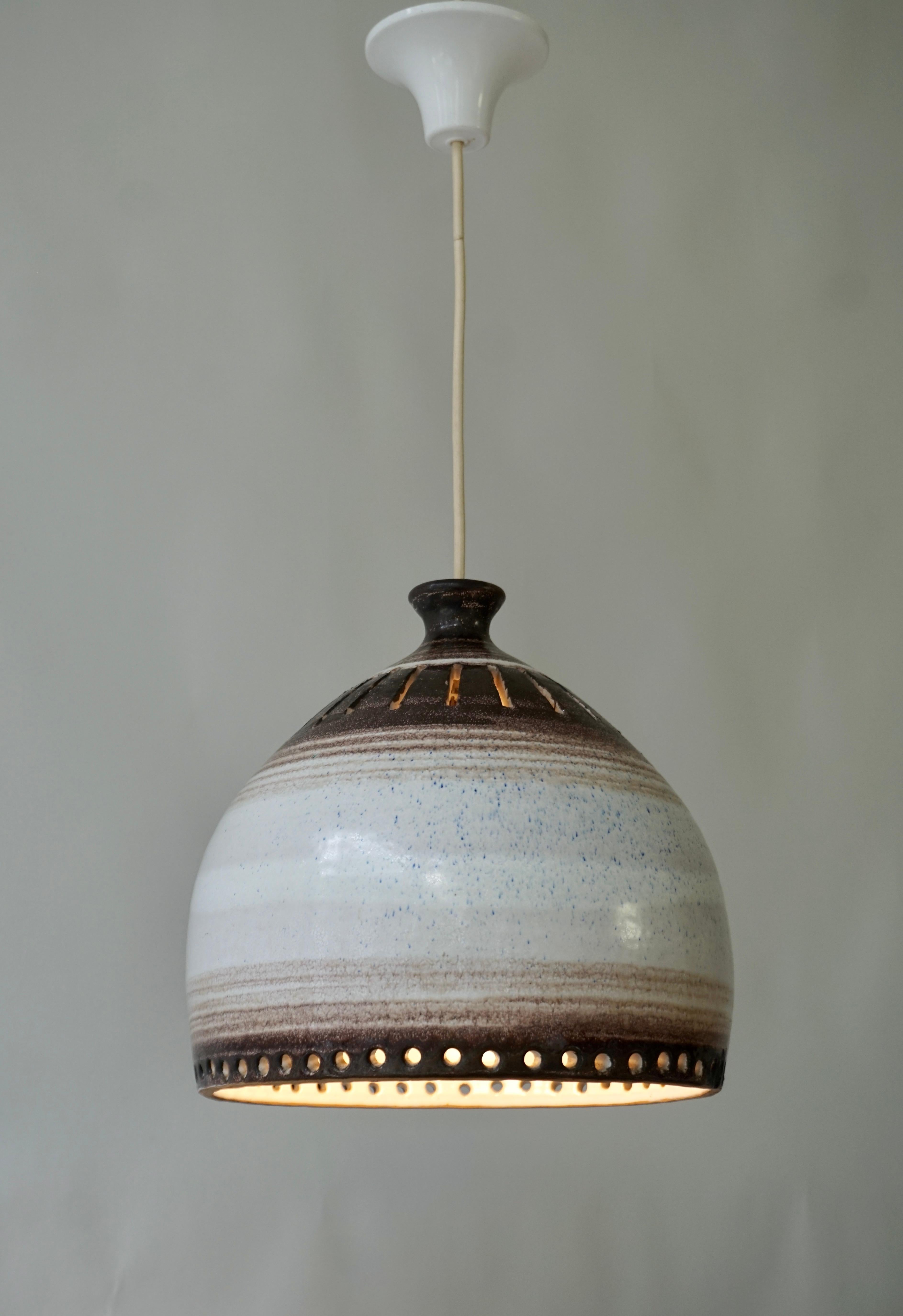 Georges Pelletier ceramic pendant light, attributed to.  

Ceramic lamp, cream-white and brown tones, adorned with perforations and circles.  
French work realized in the 1960-1970s.

Georges Pelletier is famous Belgian ceramist who was active in