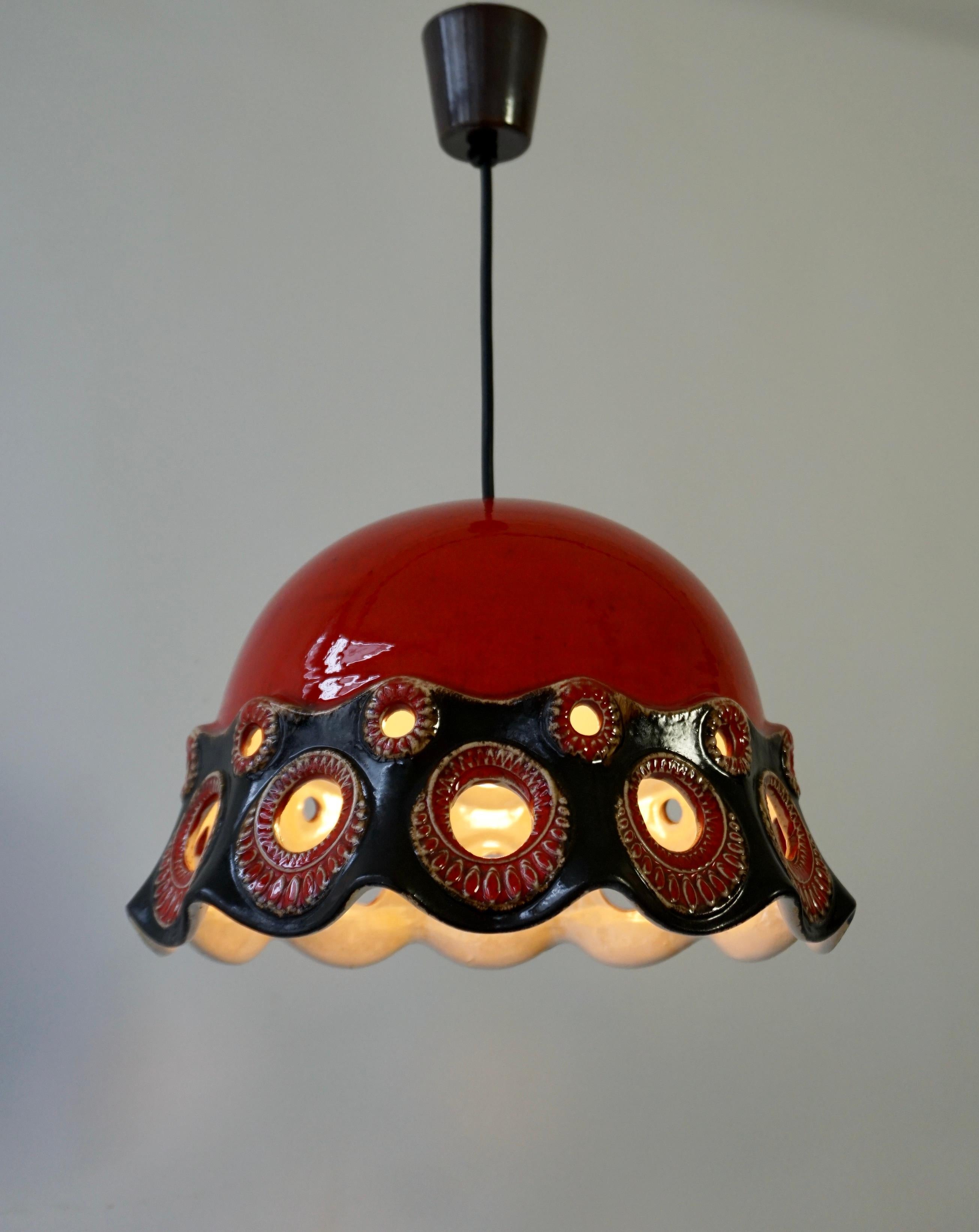 Ceramic ceiling lamp - ''PAN. Goebel'' - Germany, 1970s

Ceramic lamp with an openwork lampshade which when turned on gives a nice effect to the eye.
Object with red and black glazing.

The lamp has one socket for incandescent lamps with screw base