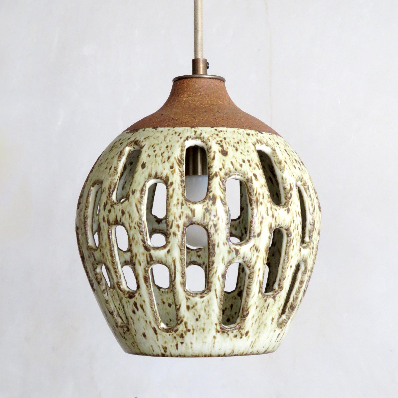 Wonderful ceramic pendant light No. 1003, designed and handcrafted by Los Angeles based ceramicist Heather Levine. High fired stoneware with speckled matte white glaze on a cork colored clay body with decorative cut outs to expose light in patterns