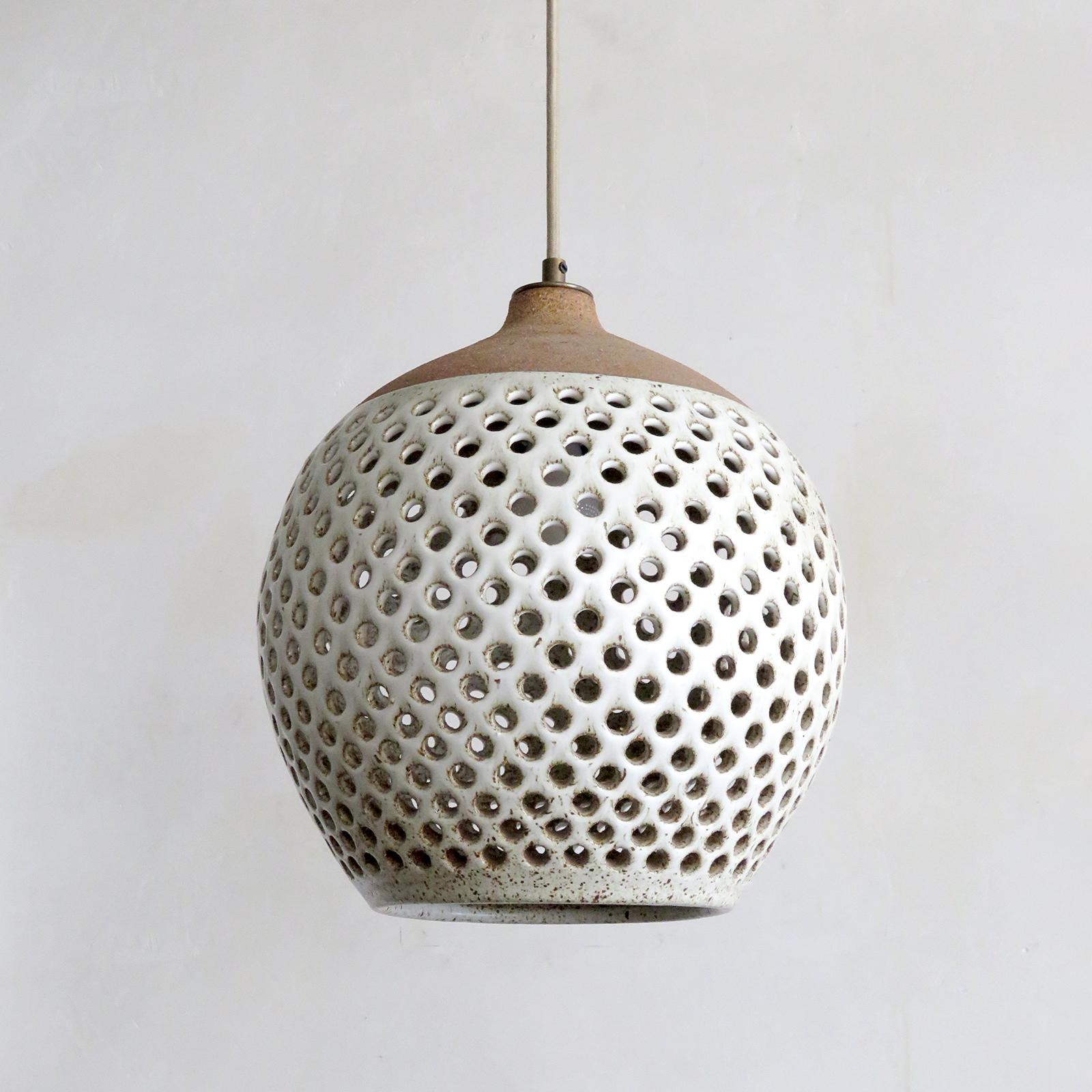 Wonderful ceramic pendant light No. L51, designed and handcrafted by Los Angeles based ceramicist Heather Levine. High fired stoneware with speckled matte white glaze on a cork colored clay body with decorative circles cut out to expose light in
