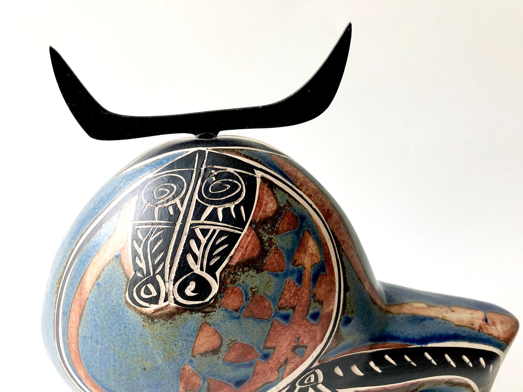 Picasso-esque ceramic bull sculpture with incised body, metal horns and wood base. Sculpture measures 10