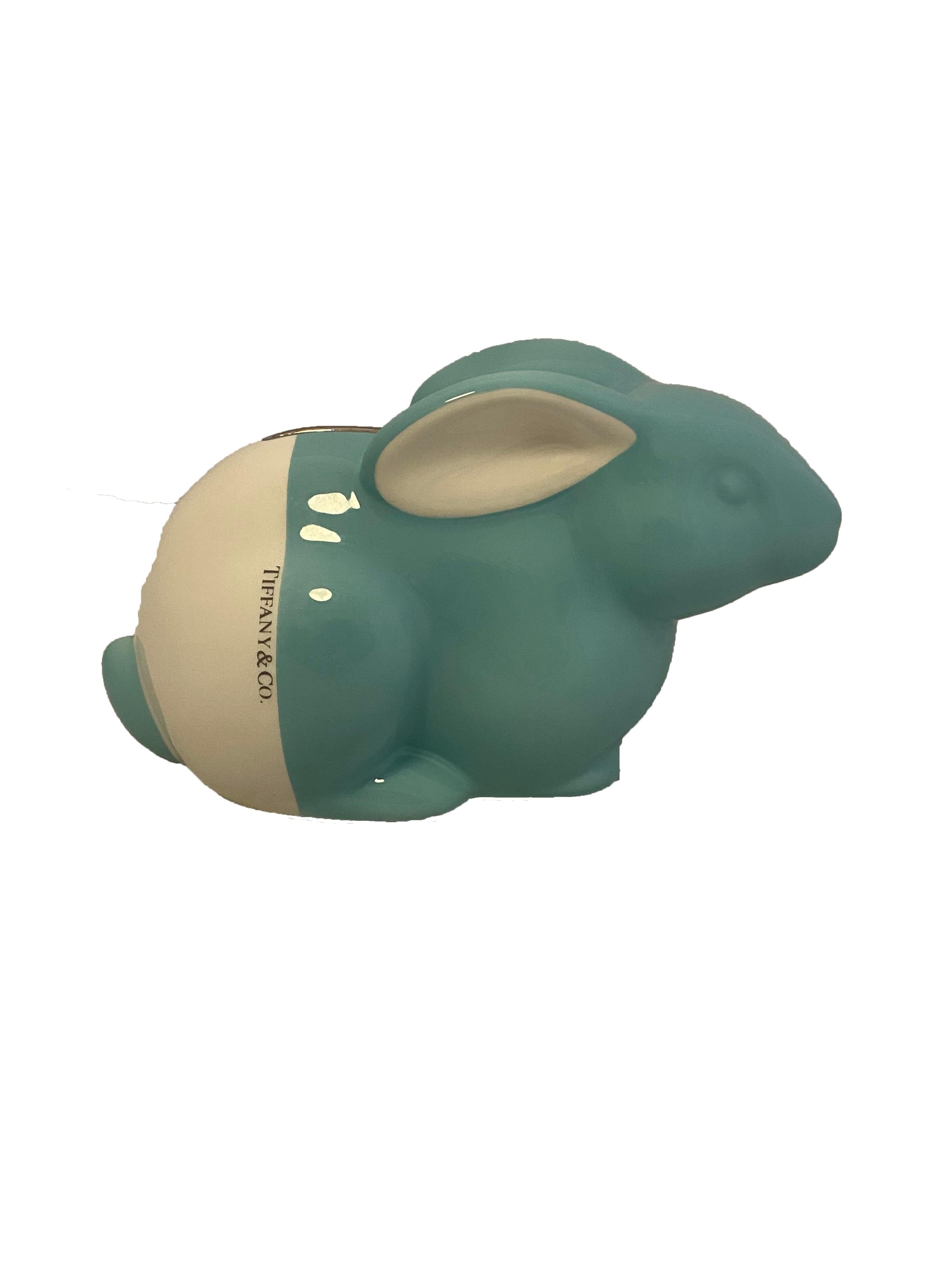 White and blue ceramic piggy bank from Tiffany & Co. Cute bunny shaped money bank crafted by Este Ceramiche in Italy and hand painted in the labels signature Tiffany blue and white with accent silver toned money slot at the top. Blue at the front