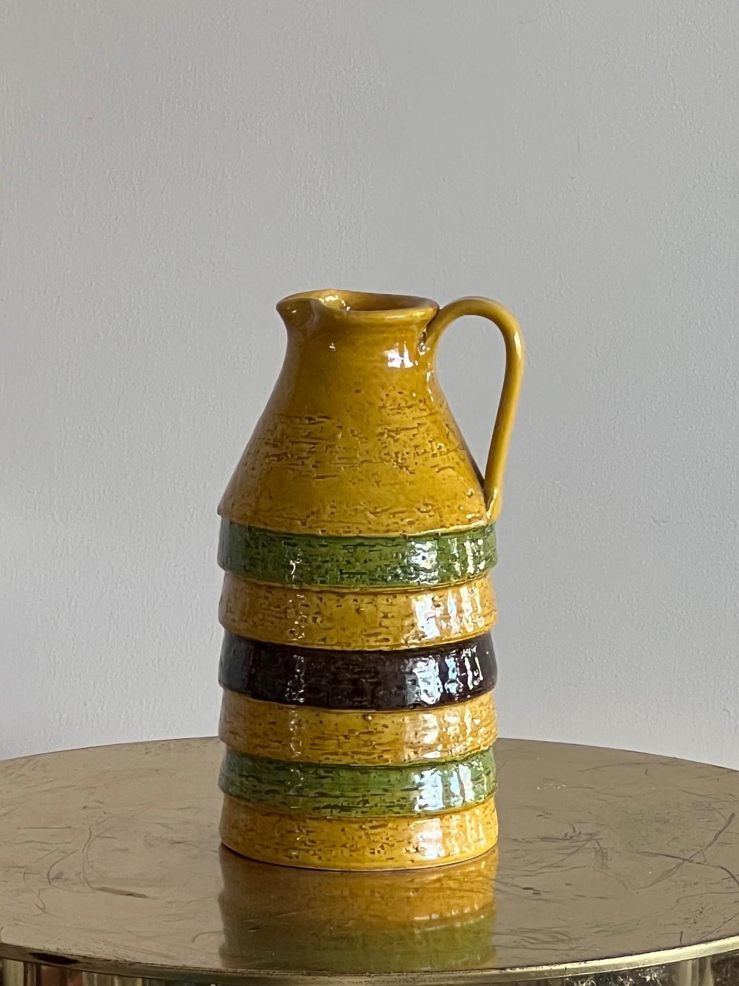 A fun 1960's ceramic pitcher by Bitossi, Italy. Yellow/orange, green and brown glaze with louvered edges add to the design character.