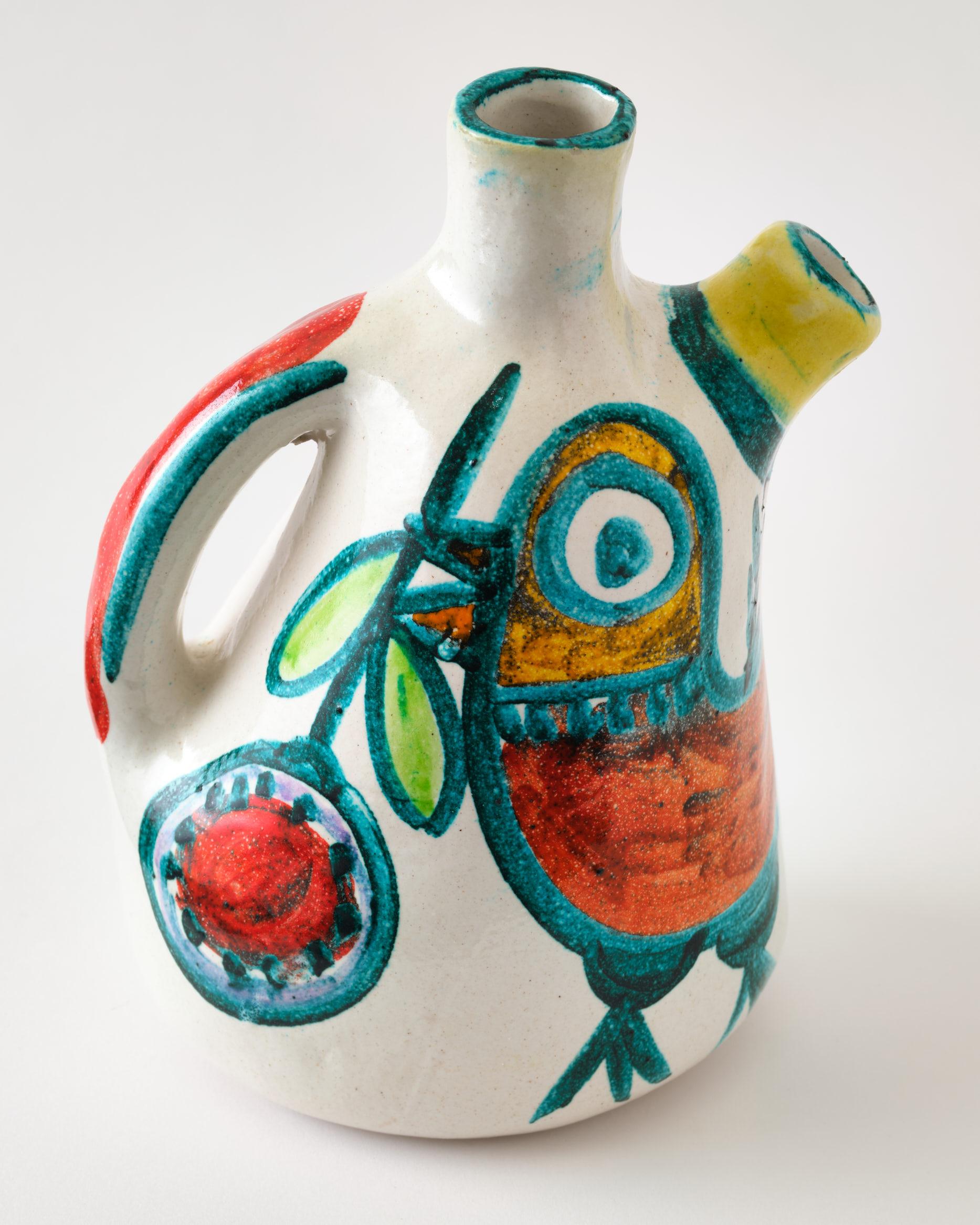 Ceramic pitcher by DeSimone, Italy, C 1960. This is a wild design with beautiful strong colors, red, green, yellow on a white background.
The pitcher is signed. It can be used as a pitcher, vase or simply a beautiful item.