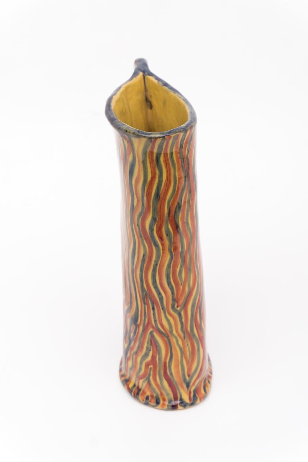 Joyful ceramic pitcher by Ceramiche Albisola. It has a smooth, glazed surface with flame like stripes in red, blue and yellow. Signed at the bottom 'Albisola', circa 1950. Albisola/Liguria is a known region for its ceramic tradition.
    