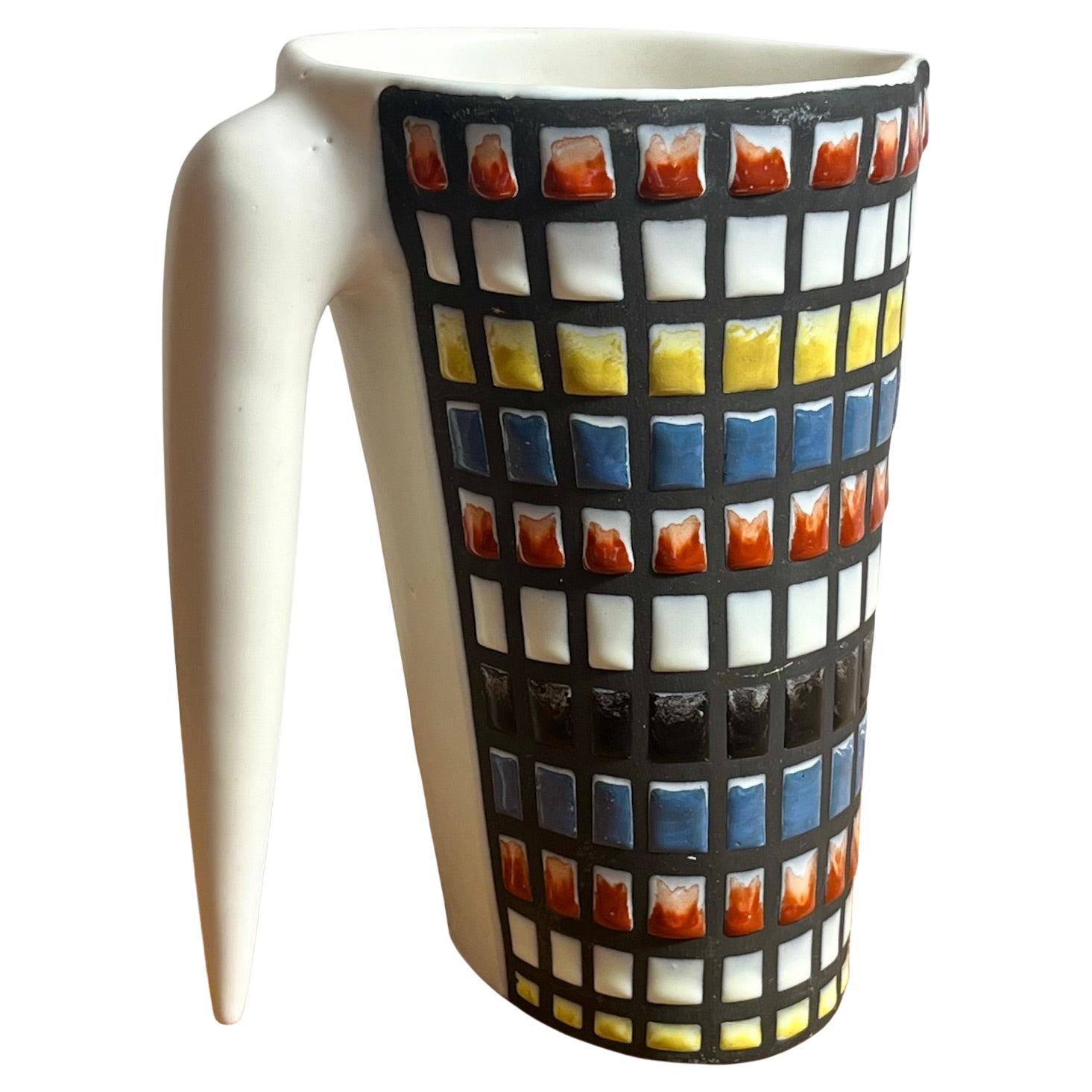  Ceramic pitcher by Roger Capron.
Glazed ceramic with geometrical  decoration in shades of red, yellow, blue and black. This pattern is referred to as 