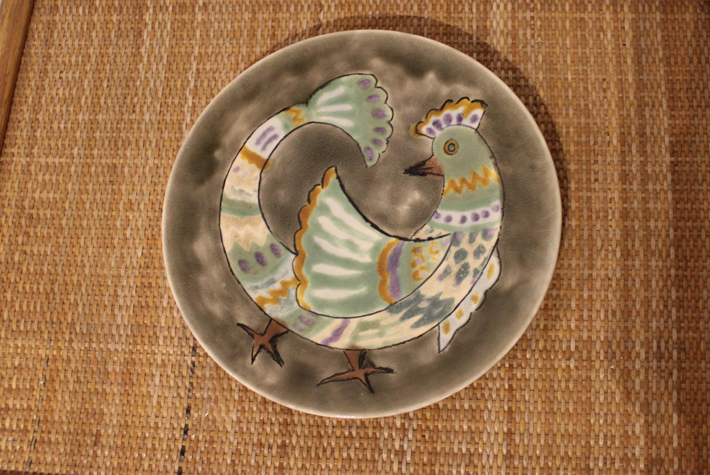 Assiette en céramique décorée d'un coq. 
Signé sous la plaque.
Travail français, vers 1950.