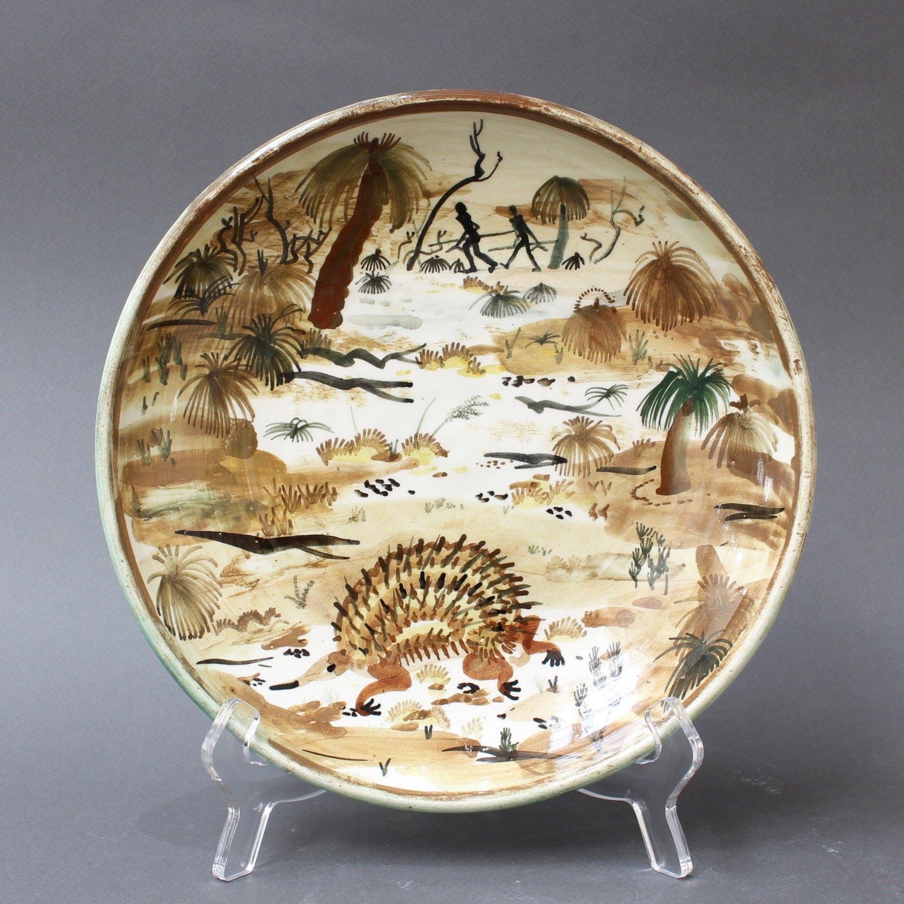 Ceramic decorative plate of Australian Bush by Neil Douglas for Arthur Merric Boyd (AMB) Pottery (circa 1950s). The circular earthenware bowl is hand painted with a bush scene of grass trees (Xanthorrhoeas), an unusual creature only found there, an
