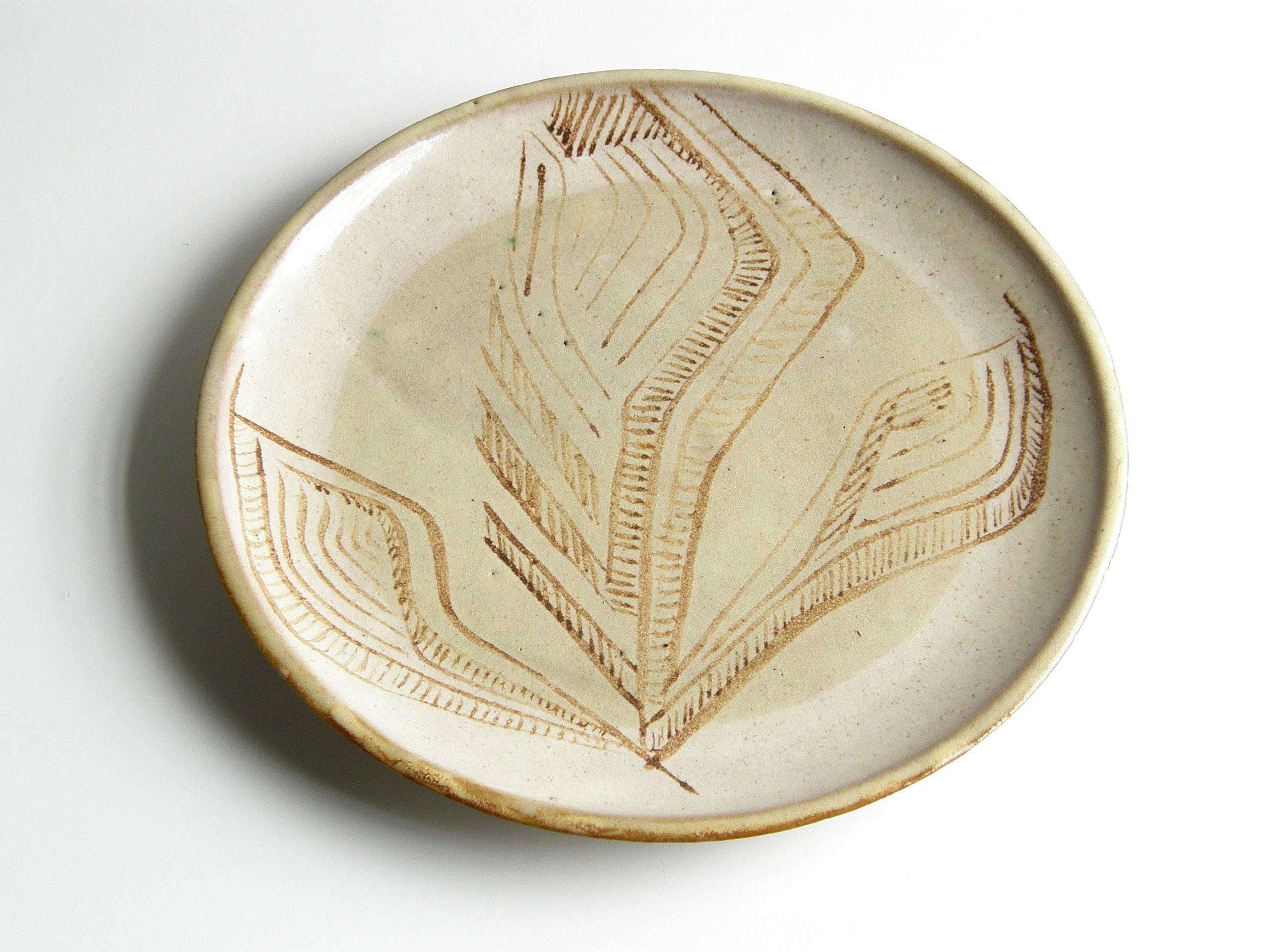 This ceramic platter attributed to Lee Rosen for Design Technics is a functional decorative art object. It's lovely to look at, and it also makes an excellent serving plate or tray. The hand painted, abstract floral design in the glaze is a nice