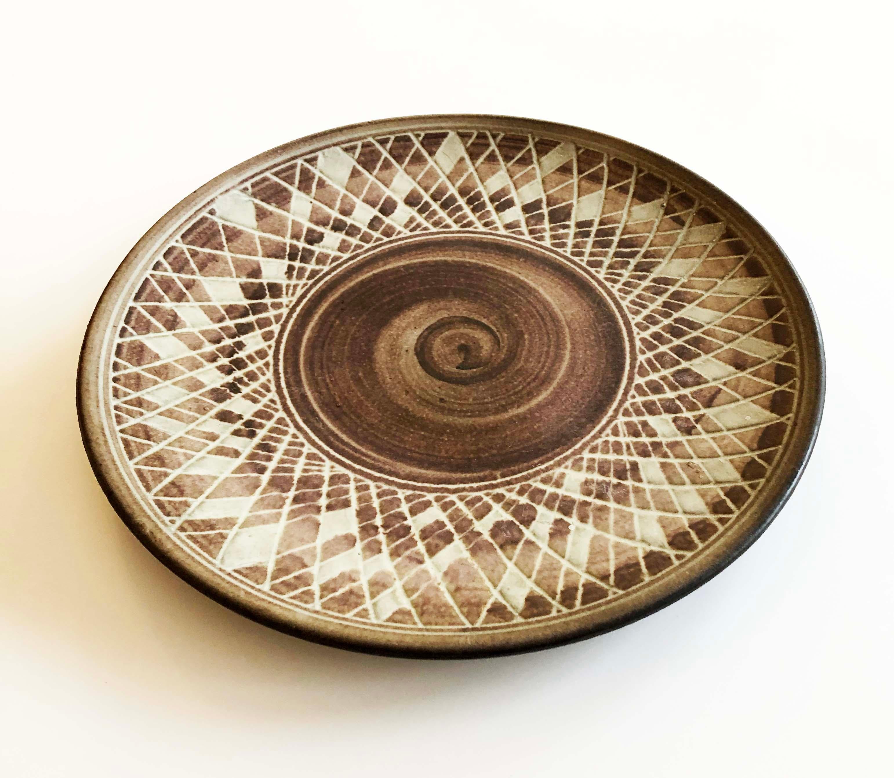 A spectacular hand-thrown earthenware ceramic platter with spiral motif and incised web overlay by Vermont studio potter Nancy Wickham Boyd. 

Earth tones. Signed.