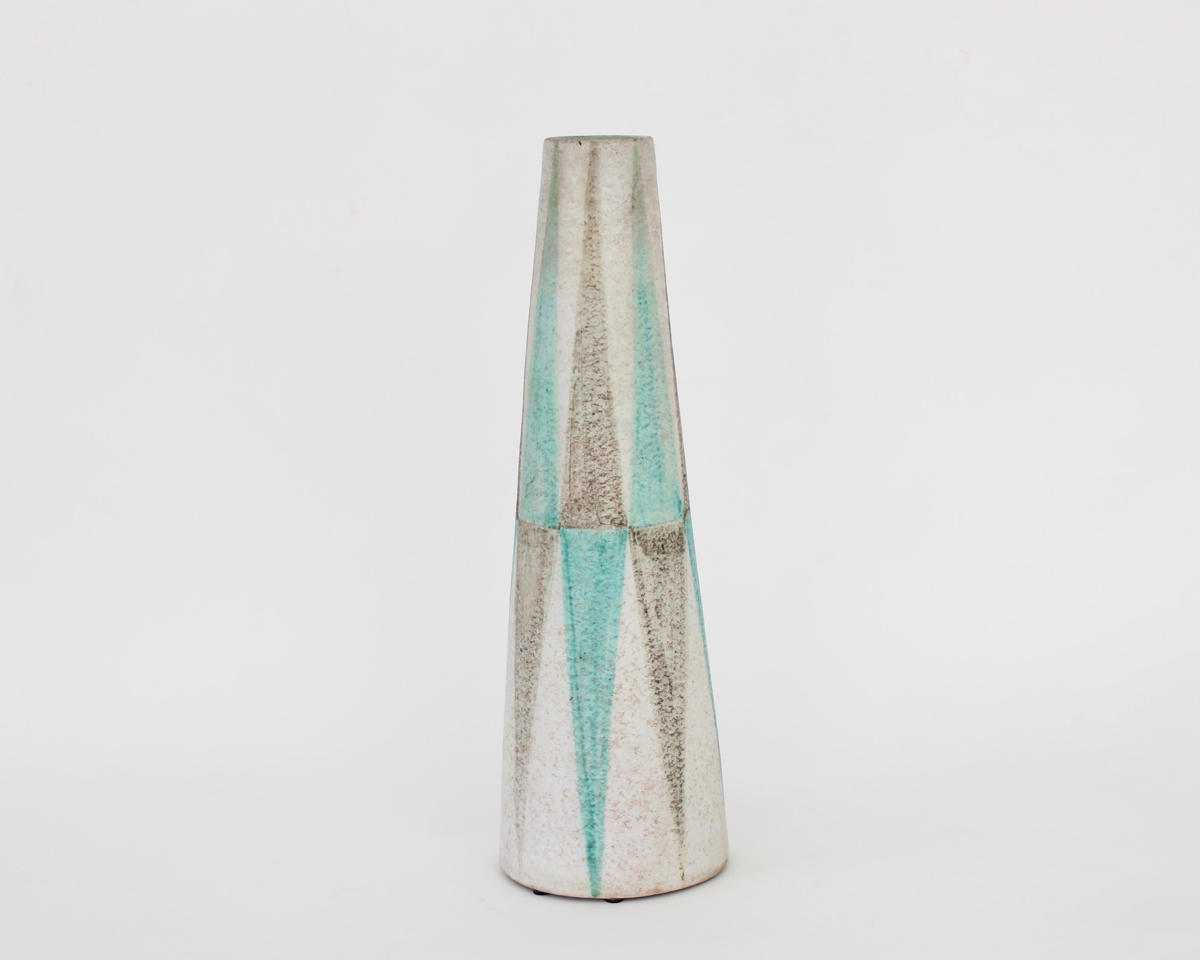 Italian ceramic vase for Raymor, most likely by Fantoni considering the amount of design work he did for Raymor and a faint trace of his signature on the base. 
Pale watery blue and brown gray glazes painted in a vertical decoration with a green