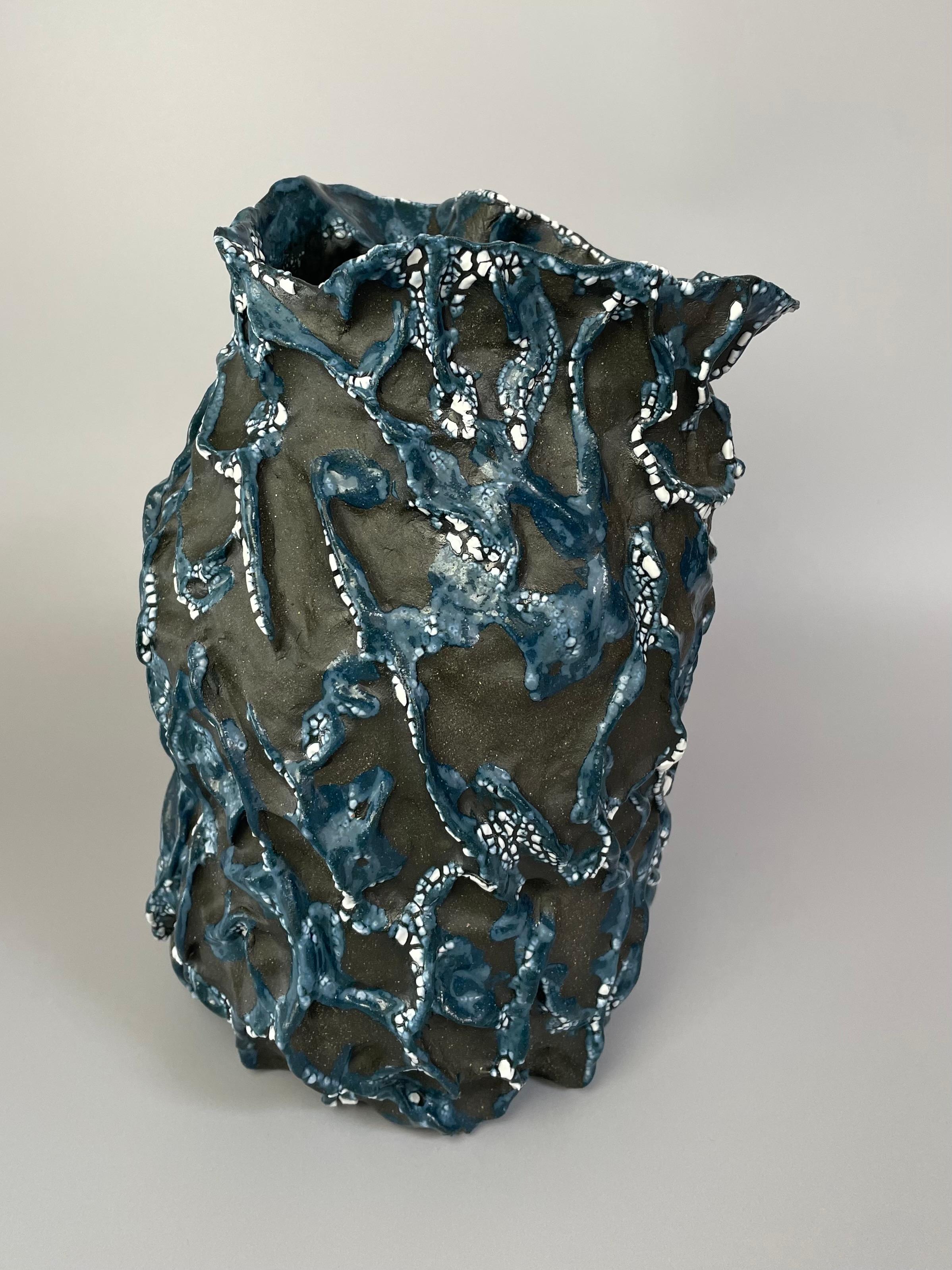 This ceramic vessel works both as a decorative piece on its own or can be used as a vase. I made this piece mixing a combination of porcelain paper clay with a black sable clay. I fired this piece to a cone 10 high fire and used minimal glazing to