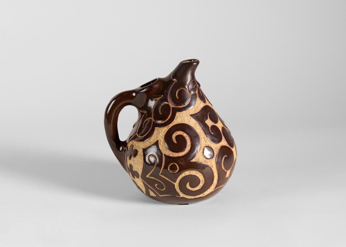 A beautiful ceramic from Ciboure pottery, this narrow spouted pitcher is covered in a swirling, cloud-like pattern of brown and tan. Executed by Etienne Vilotte, one of the founders of the Ciboure Pottery works.

Incised: Jorraila / pièce unique