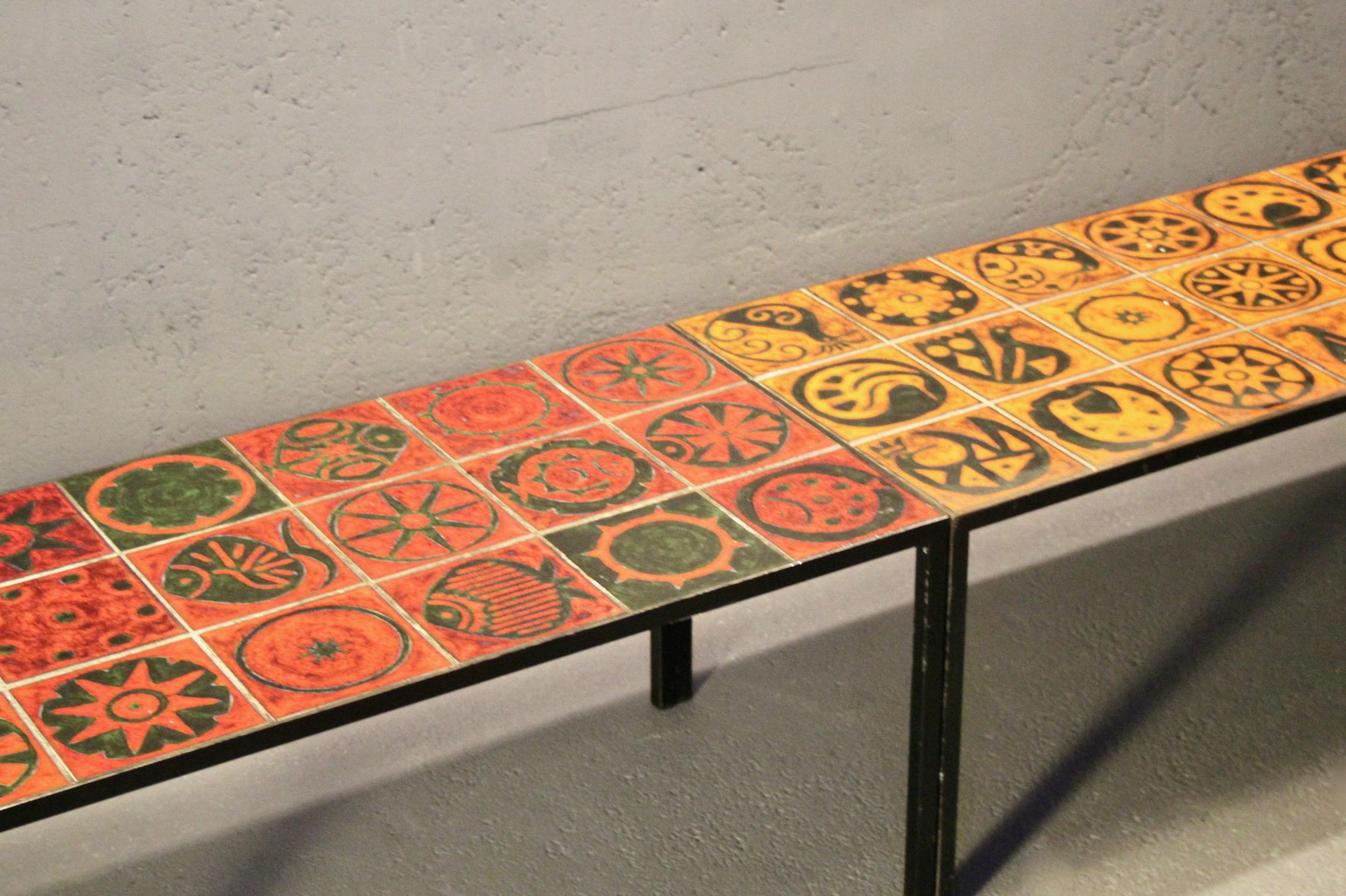 Deux tables pouvant être combinées en une seule, en céramique rouge et orange ; l'une est plus longue (107 cm) que l'autre (93 cm).