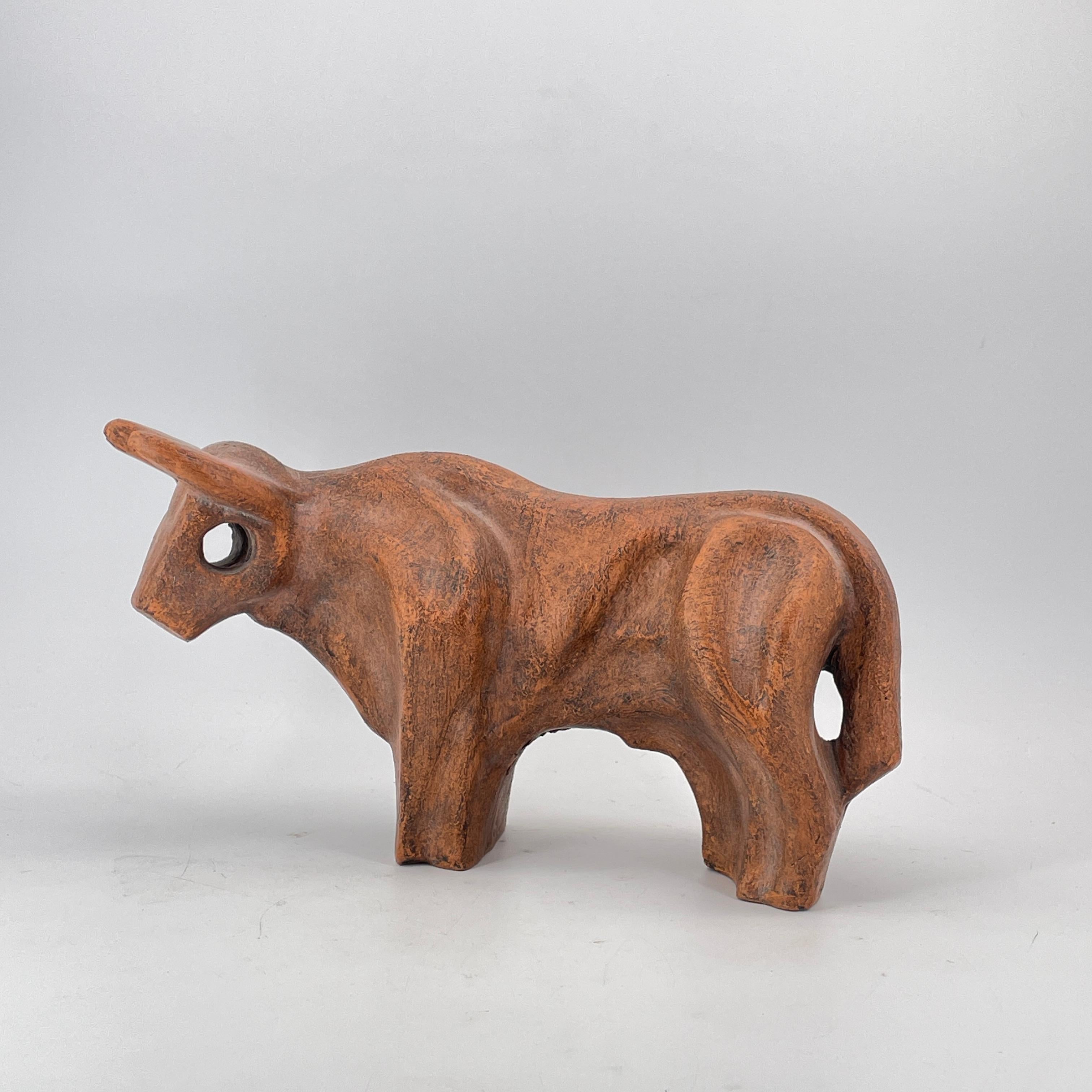 USA, c.1970s. Unknown artist, procured from a Washington DC Area estate.  A resting Bull sculpture stylized with hole through the head. The Bull is a symbol of prosperity, diligence and wealth.