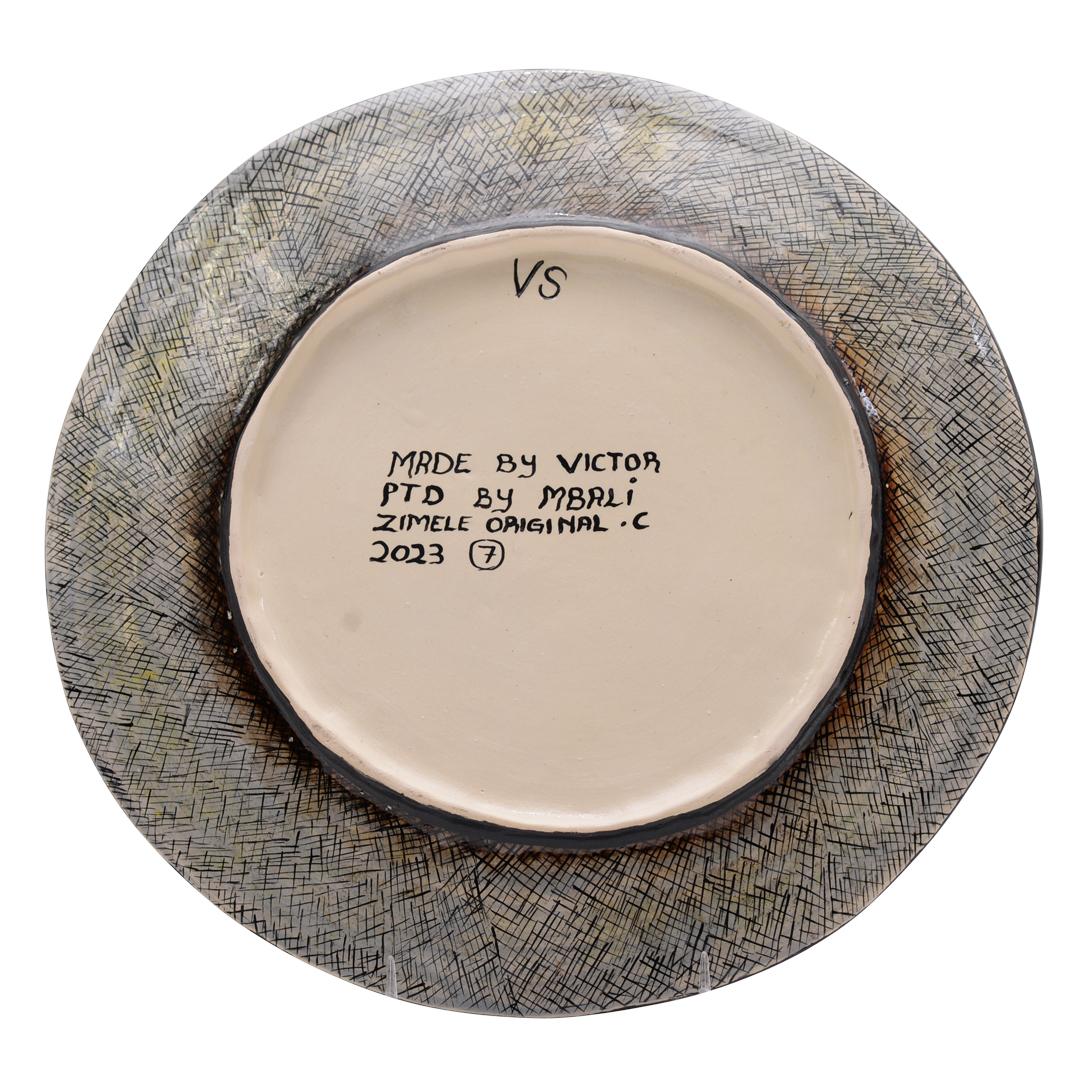 The Ceramic Rhino Plate, a stunning creation from Zimele Ceramics in South Africa, is a testament to the rich tradition of African artistry. Hand-sculpted by Victor Shabalala and intricately hand-painted by Nompilo Zaba, this plate stands as a