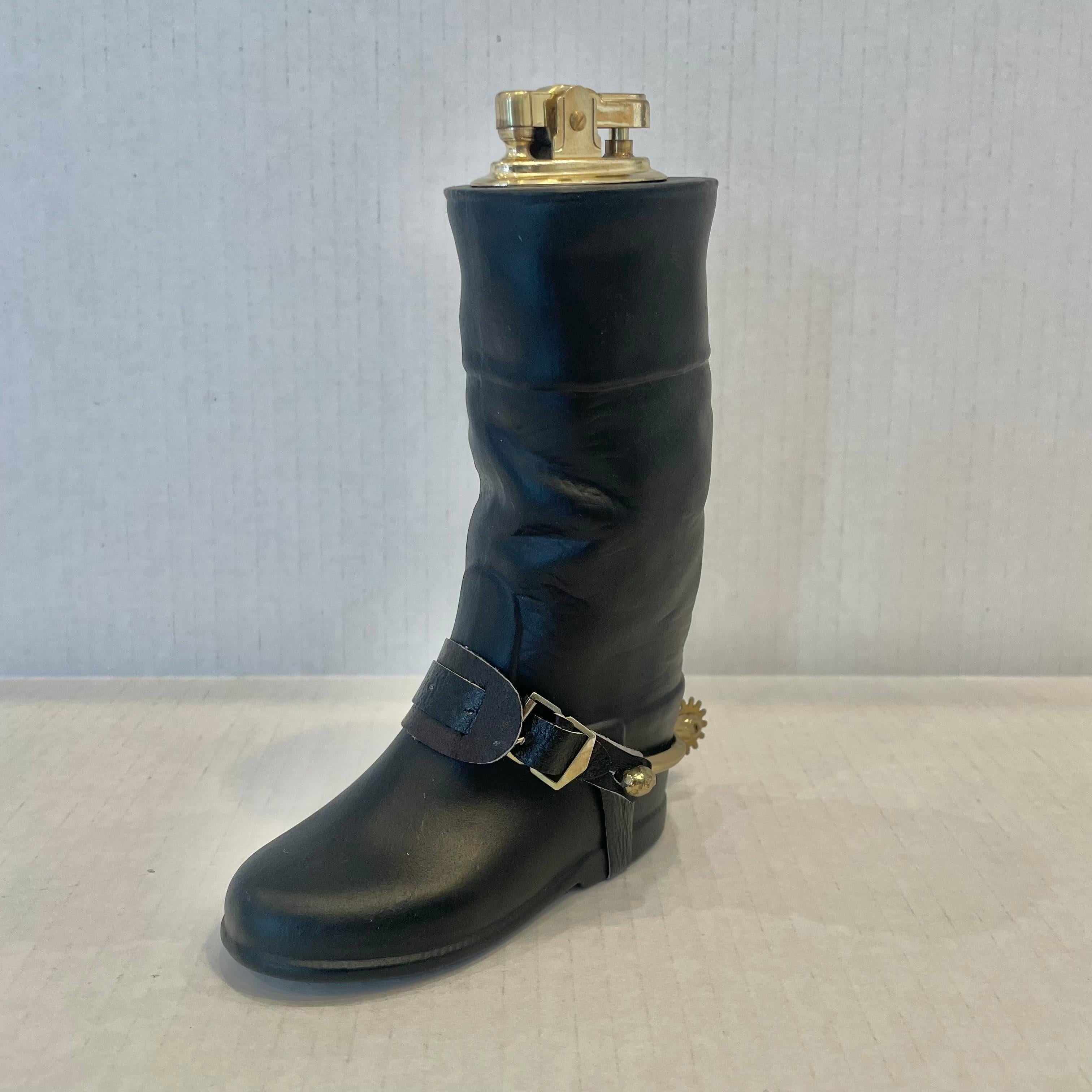 Cool vintage table lighter in the shape of an equestrian riding boot. Made completely of ceramic painted in a matte black with a hollow body. Beautiful gold spur and leather accent details. Cool tobacco accessory and conversation piece. Working