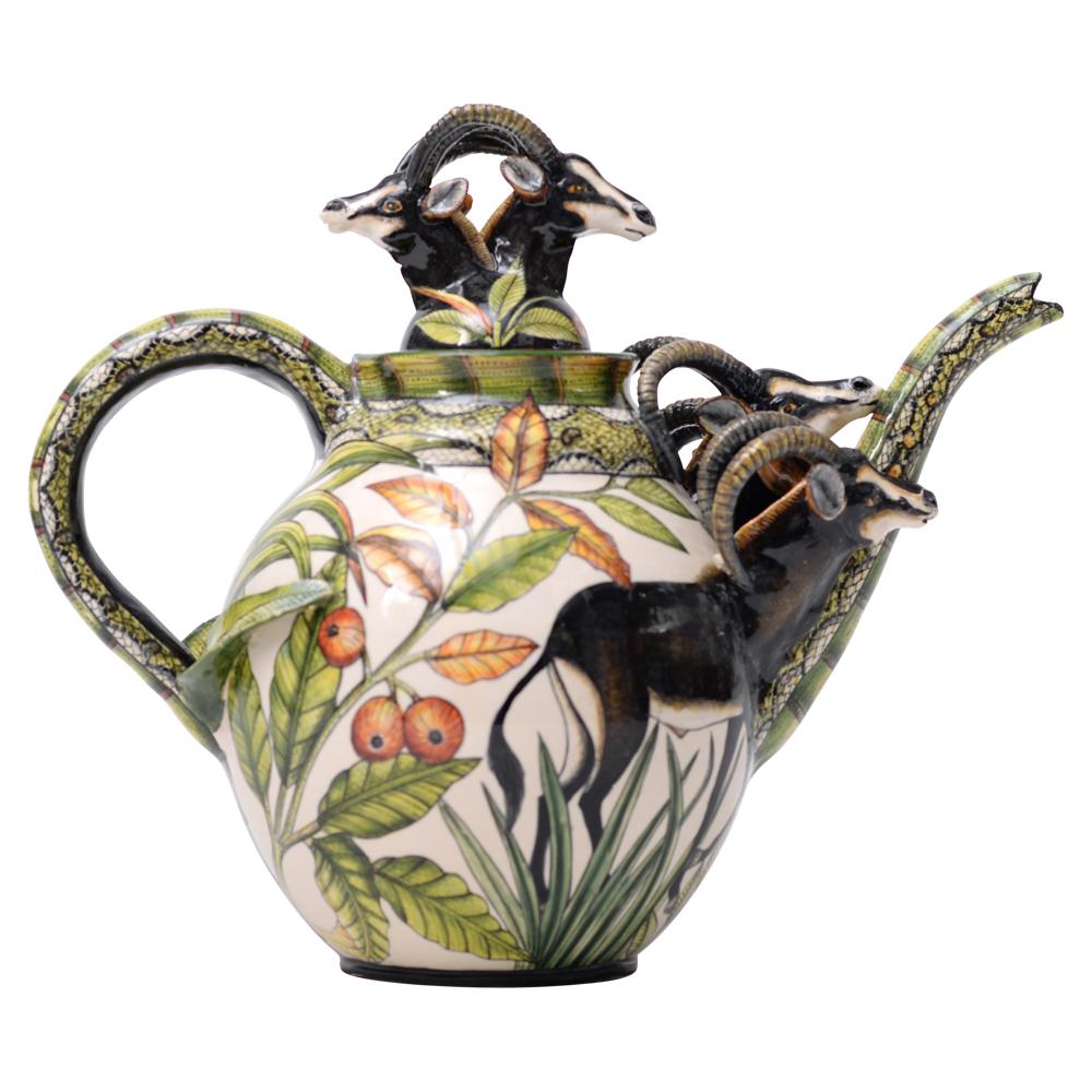 Die Zobel-Teekanne von Senzo Duma Ceramic Arts ist ein Meisterwerk afrikanischer Handwerkskunst, das von Senzo Duma selbst handgeformt und handbemalt wurde. Mit einer Höhe von 12 Zoll, einer Länge von 14 Zoll und einer Breite von 8 Zoll verkörpert