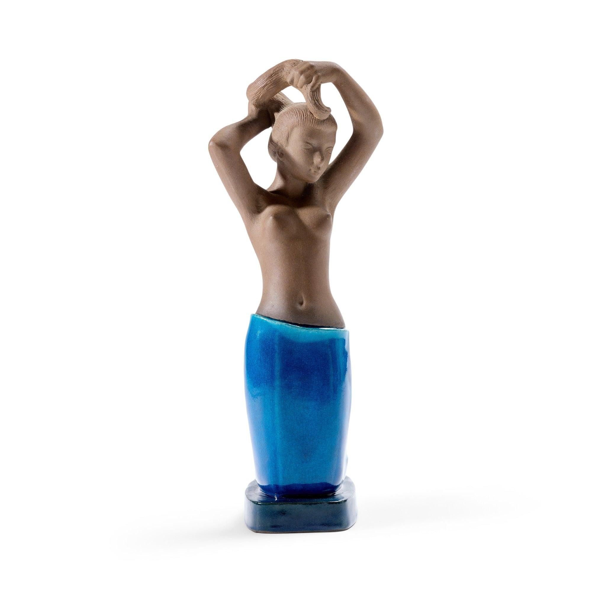 A beautifully modeled and graceful ceramic sculpture of a woman, the body having an unexpected and striking combination of unglazed brown stoneware and a rich turquoise glaze.