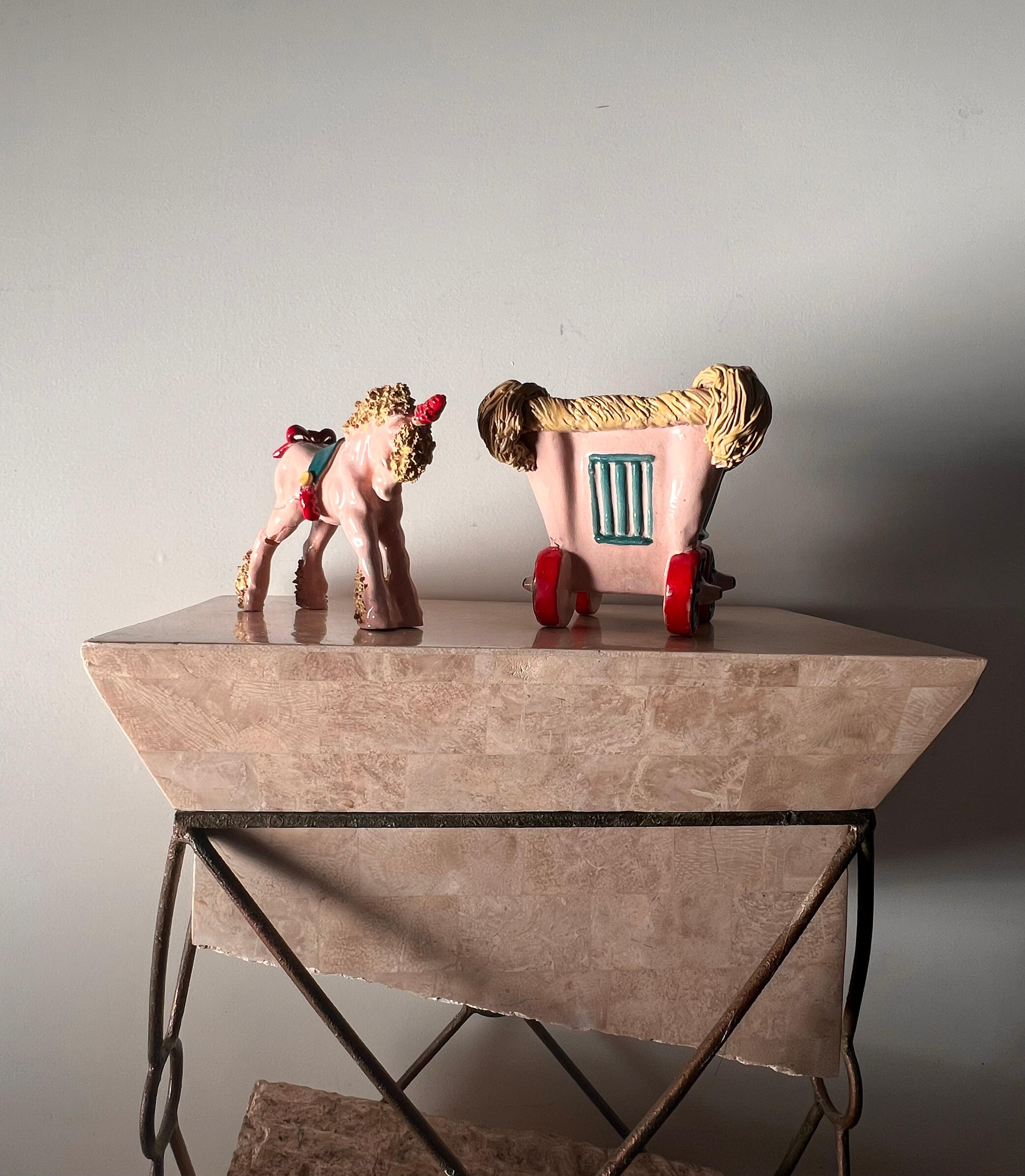 A whimsical little statue of a pony unicorn and carriage by Bill Meyer, signed, 20th century. The pony’s back leg has been repaired so please see photos for details; priced accordingly. Pale pink with pastel chartreuse hair and hooves, teal saddle