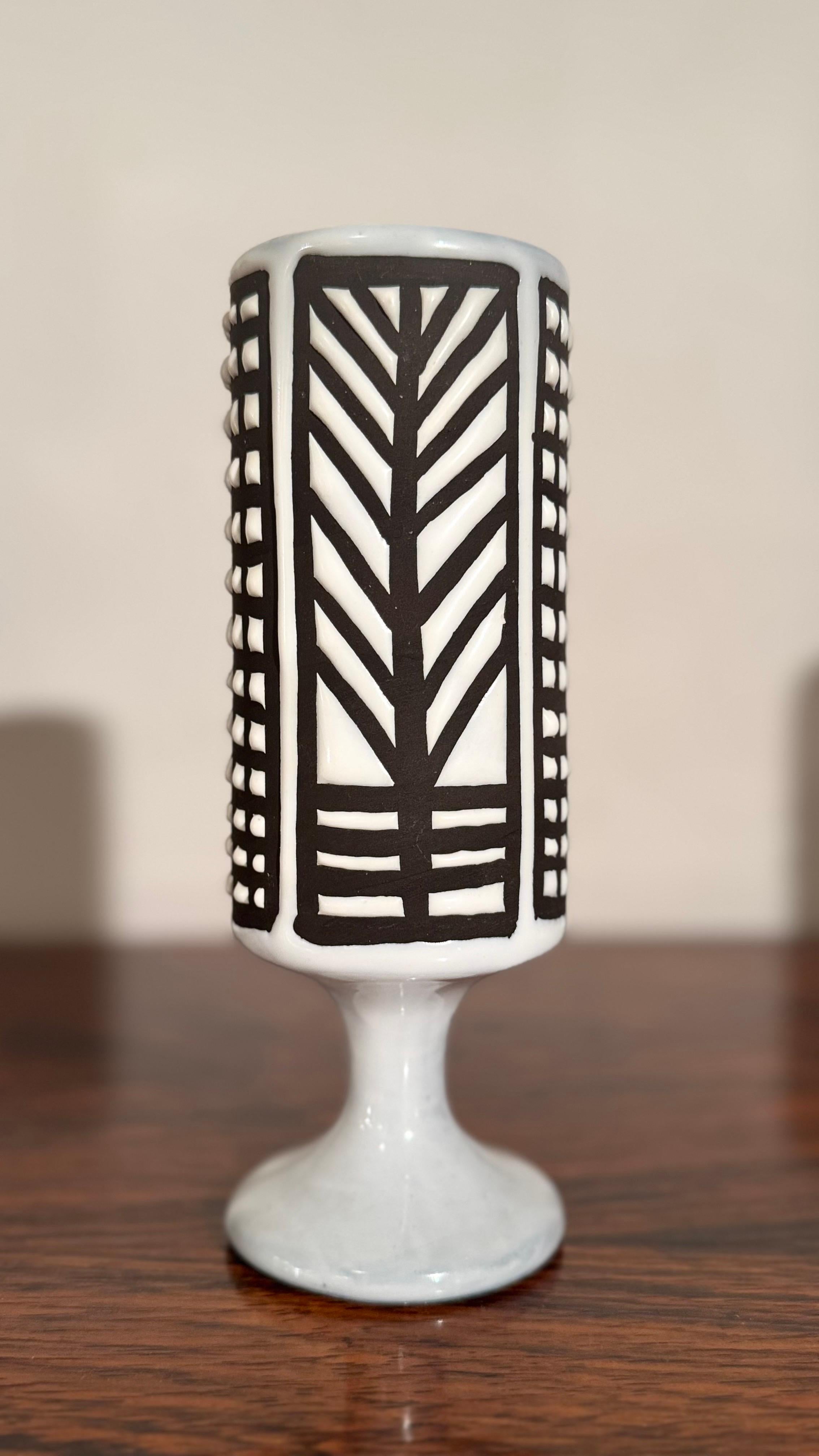 An abstract beautiful, graphically designed, cup-shaped vase with a white glaze and a geometric design in black lines. The result is an almost architectural effect, characteristic of Roger Capron's modernist and decorative style. A highly