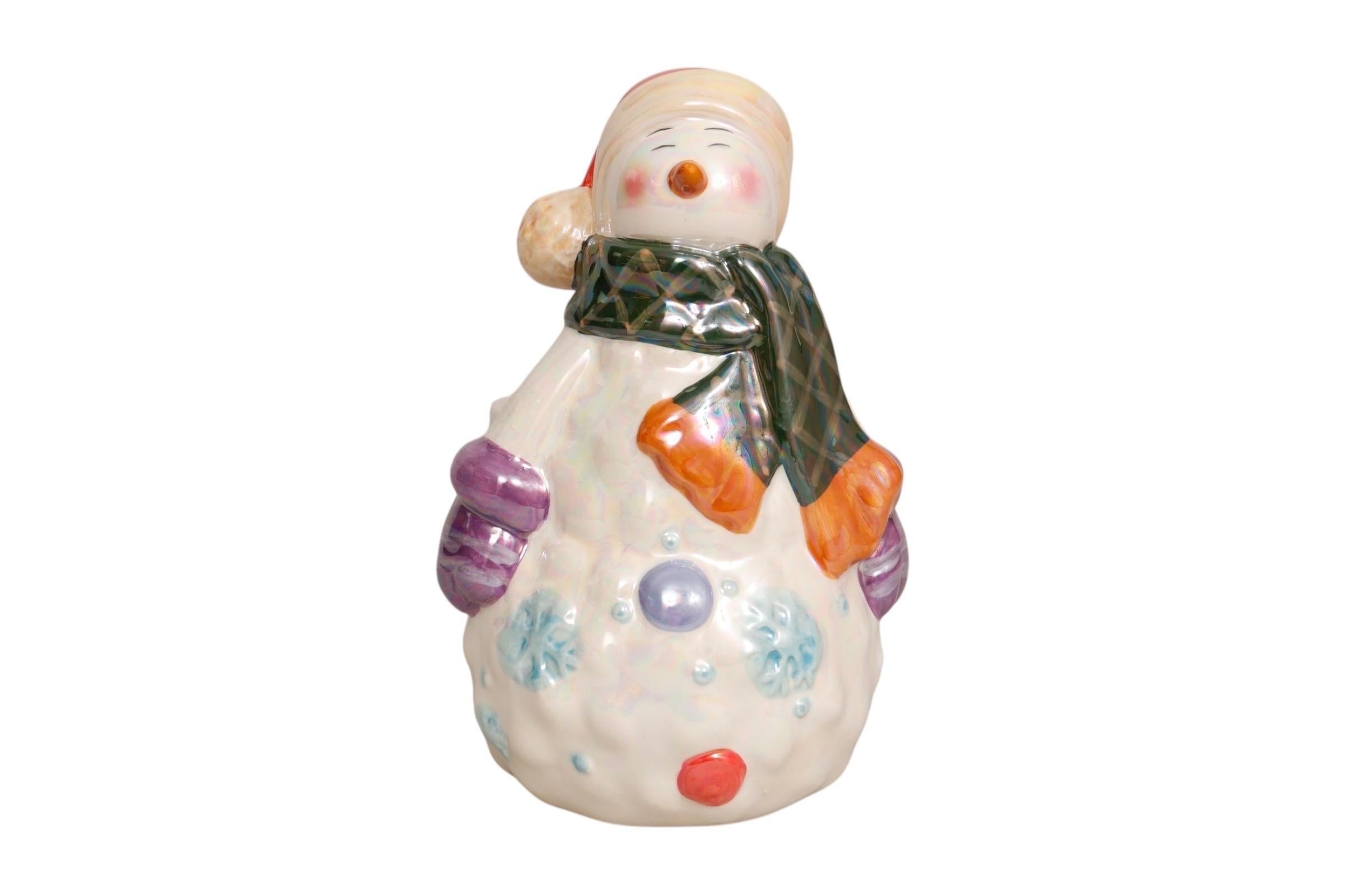 A 1980’s ceramic plant pot holder with a snowman figure made by Bloom Rite. The snowman is wearing a Santa hat, green scarf and purple gloves, decorated with baubles and snowflakes, all finished in an iridescent glaze. Marked underneath Bloom Rite