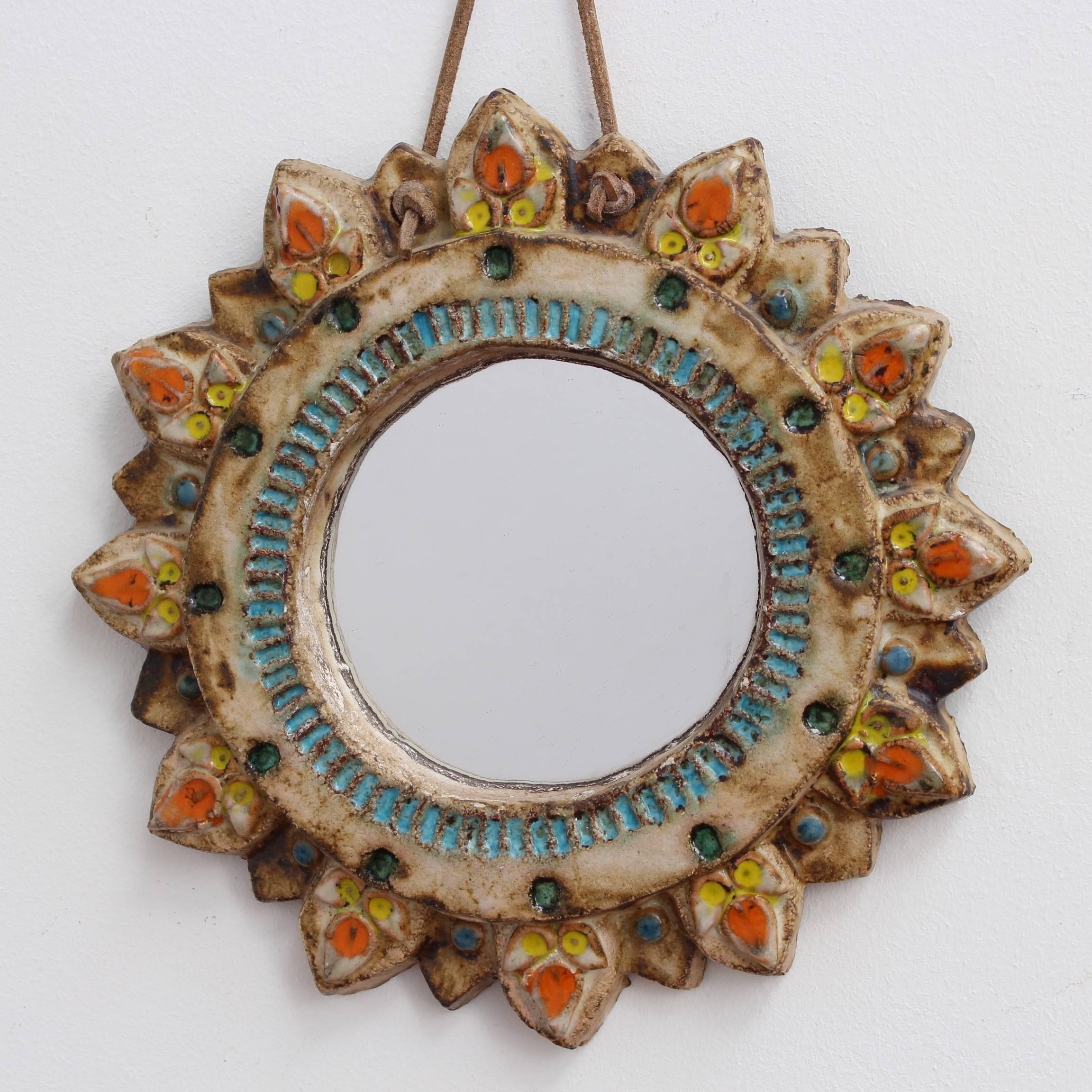 Ceramic sunburst mirror with glazed highlights by La Roue, Vallauris, France, circa 1950s. A charming rustic mirror with colourful decorative glazed details surrounding the circular mirror and emanating from the individual rays. In very good vintage