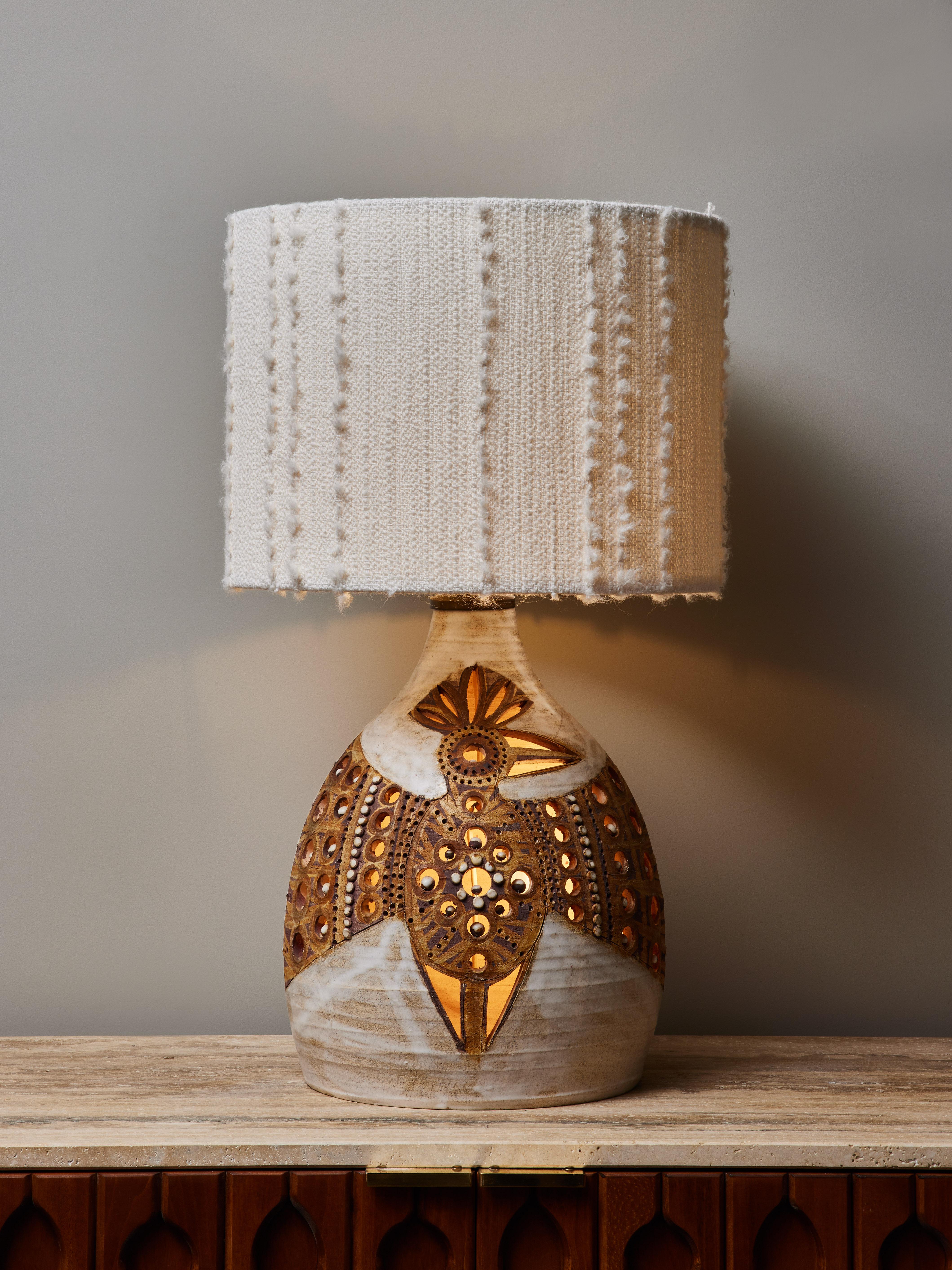 Rare example of the work of Georges Pelletier, this ceramic table lamp is quite exceptional considering the glazed décor that take the whole surface of the lamp. A stylized eagle, made with various tones of browns and beiges. The artist definitely
