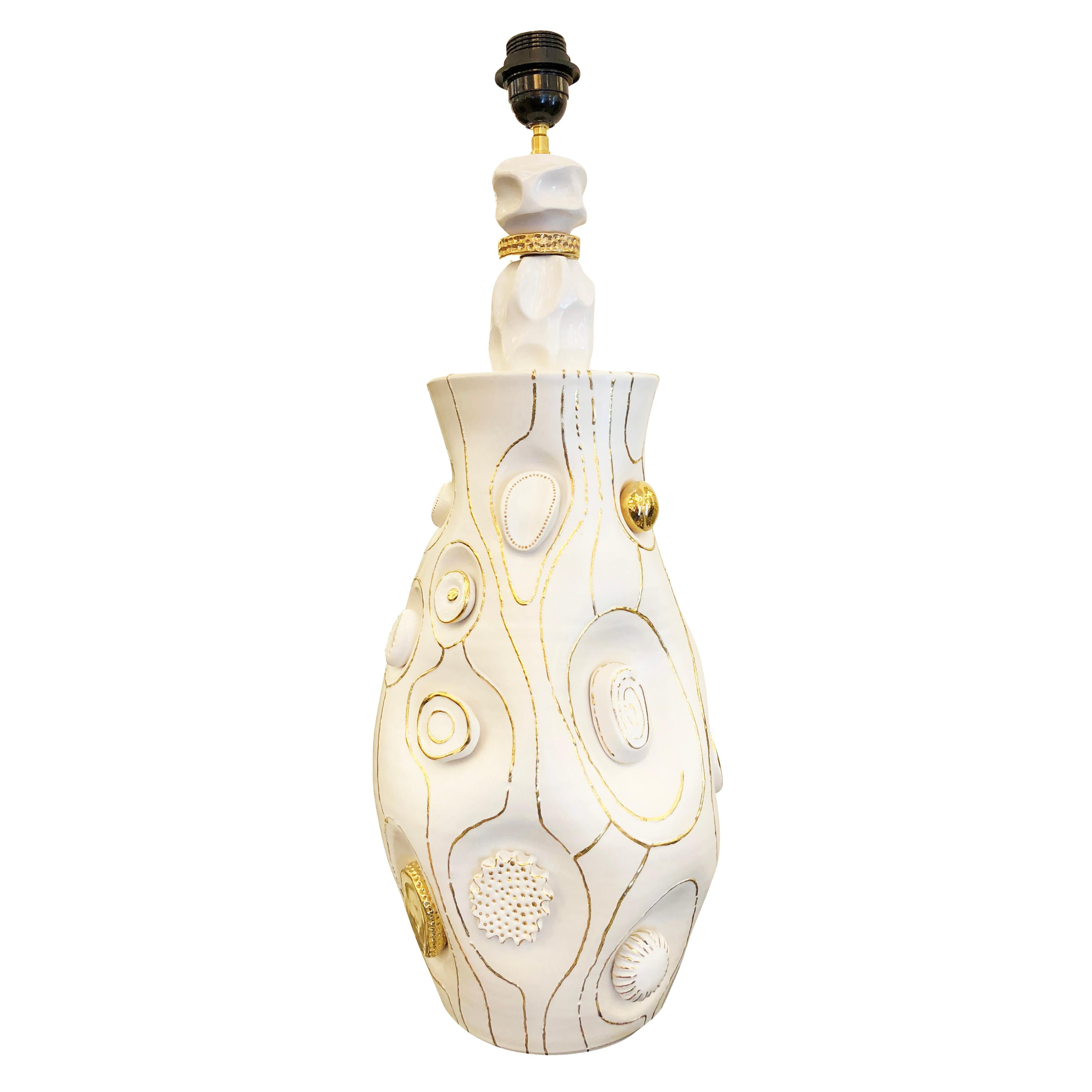 Handmade table lamp by contemporary, Paris based ceramicist, Veronique Rivemale. The organic white body is decorated with irregular medallions and gold lines. 

Measures: Diameter 10”

Height 26”.

 