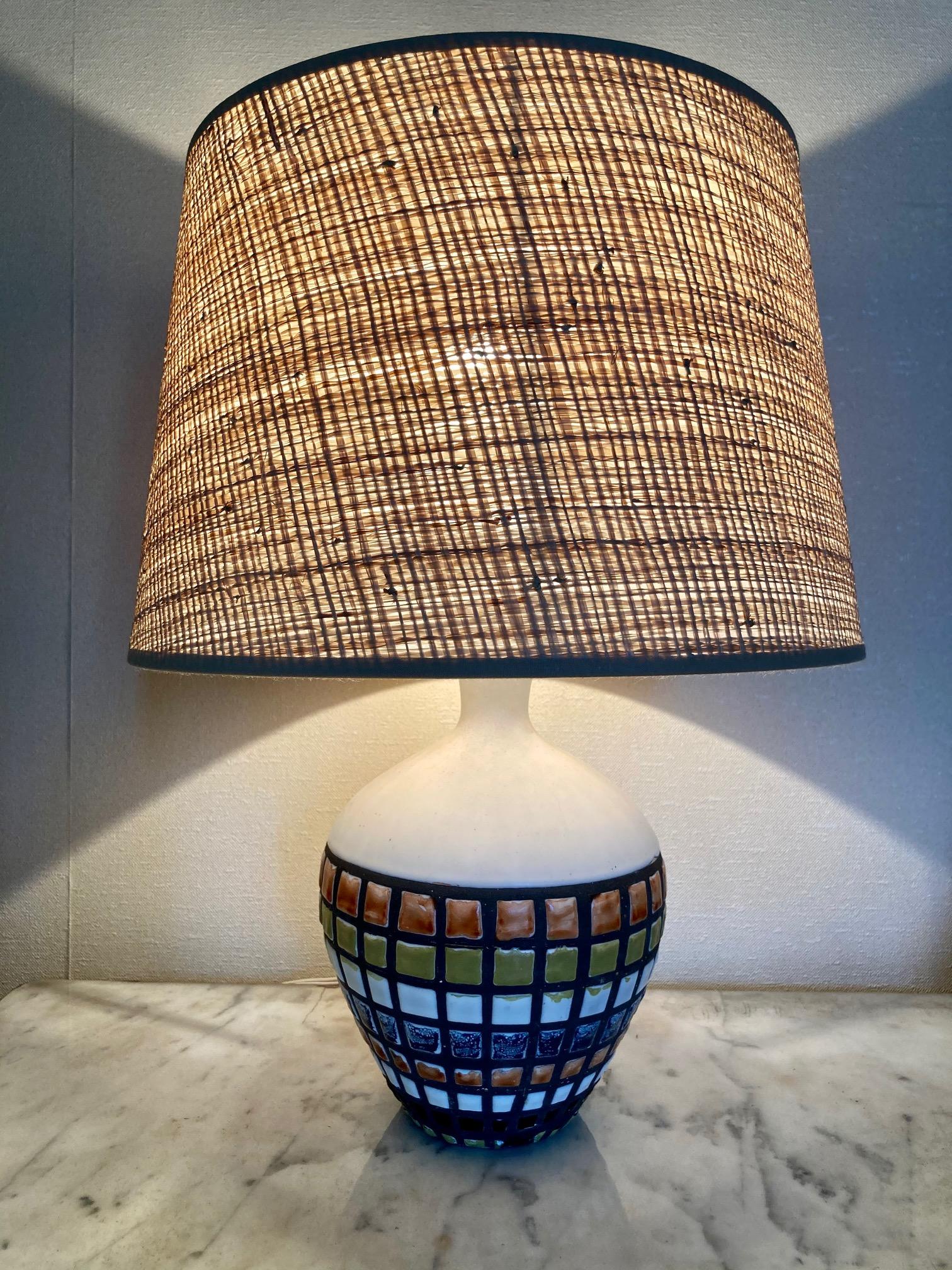 A bottle shape table lamp 
White enamelled ceramic with polychrome pavé design .
Roger Capron, Vallauris 1960.
signed Capron France B3
Vintage shade in excellent condition. 
Measures: Total height 40 cm, ( 15.8 inches )
Ceramic height 20 cm, (7.9