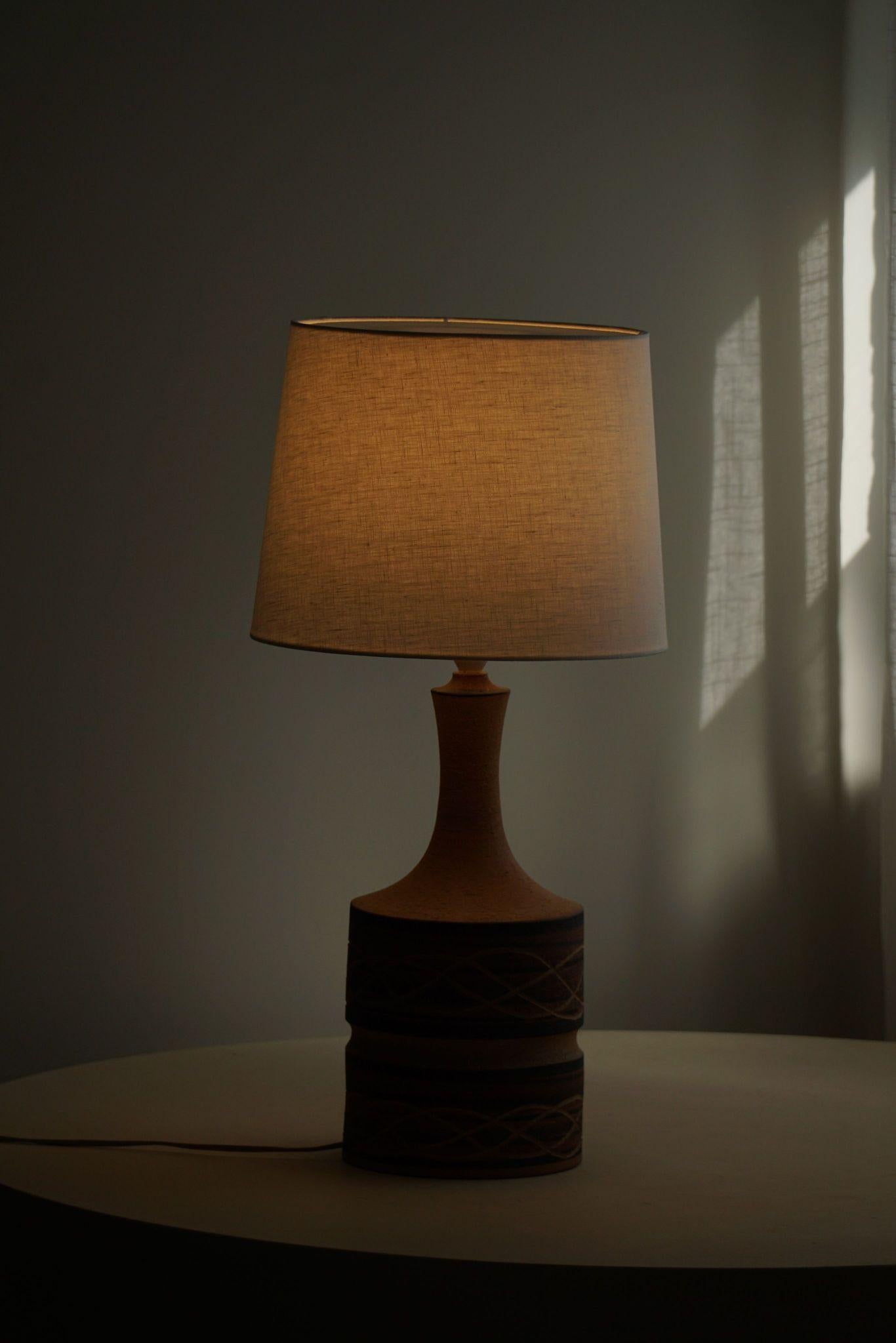 Danish Modern circular shaped stoneware table lamp. Made in various brown earthen colors. Made in the 1970s by Axella Stentøj, signed underneath. 

This item is in a great vintage condition. This beautiful and calm lighting complements many types of