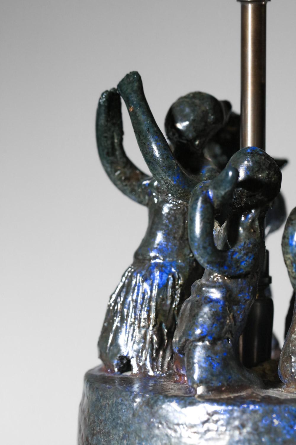 Lampe de table française des années 60 présentant des figures dansantes sur le dessus de la lampe. Base en céramique émaillée dans les tons de bleu, teinte de présentation sur demande. Vintage By, avec une belle patine du temps sur la céramique