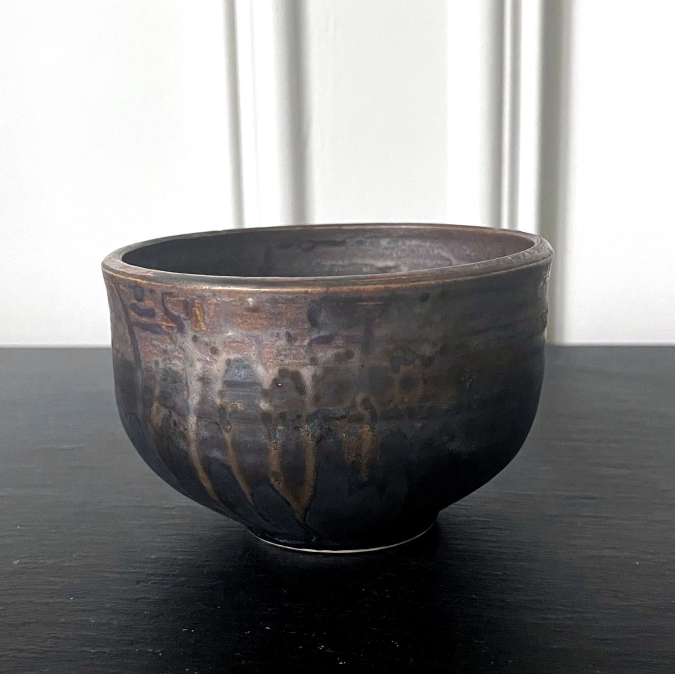 A glazed ceramic tea bowl (chawan) by Japanese American artist Toshiko Takaezu (American, 1922 - 2011). The well-balanced form is hand built and shows slight irregularity, further accentuated with wheel grooves circumventing the exterior. The