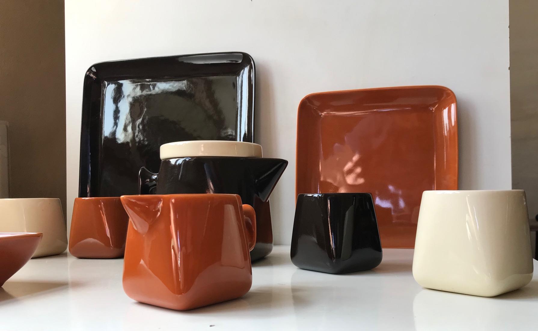 A rare Teaservice consisting of a teapot, creamer and sugar bowl, 2 cake serving dishes and 4 cups. The shape of the teapot, creamer and cups starts of as a square at the bottom and transform fluently into a circle at the top. All pieces features