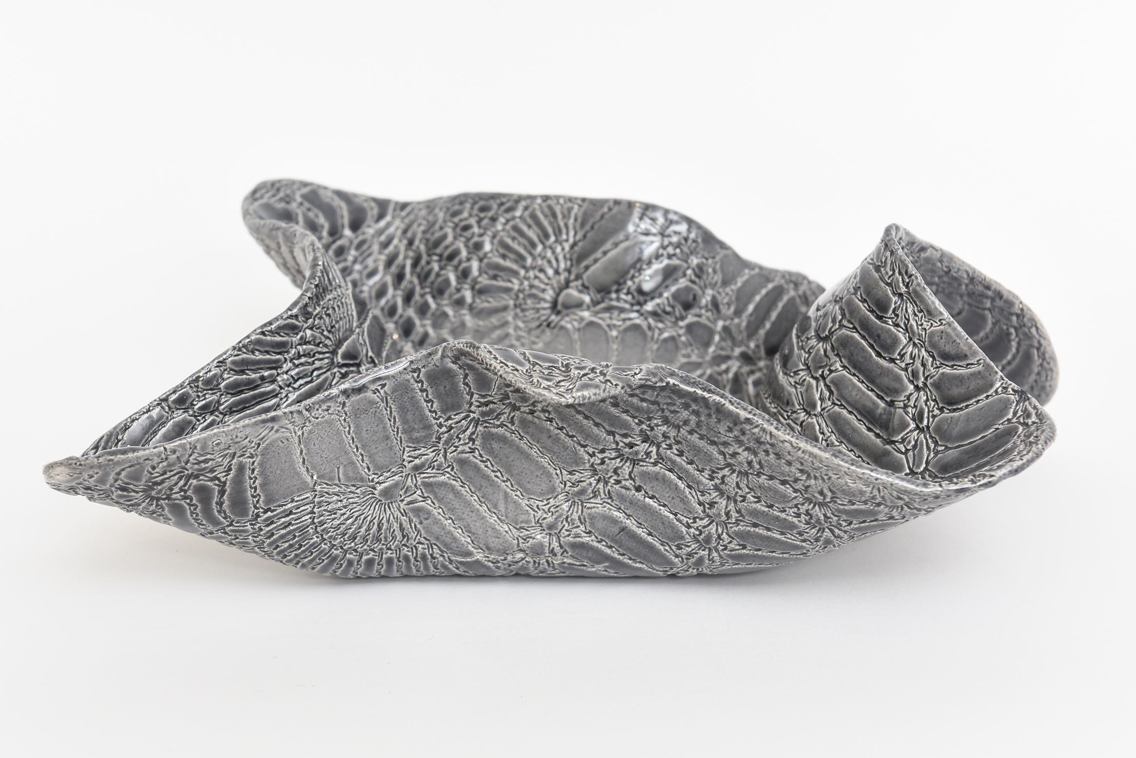This amazing textural snakeskin patterned ceramic bowl is vintage and has colorations and hues of grays to charcoal grays to white outlines. It looks like glass. The biomorphic shape and sculptural entity makes for a fabulous bowl from every
