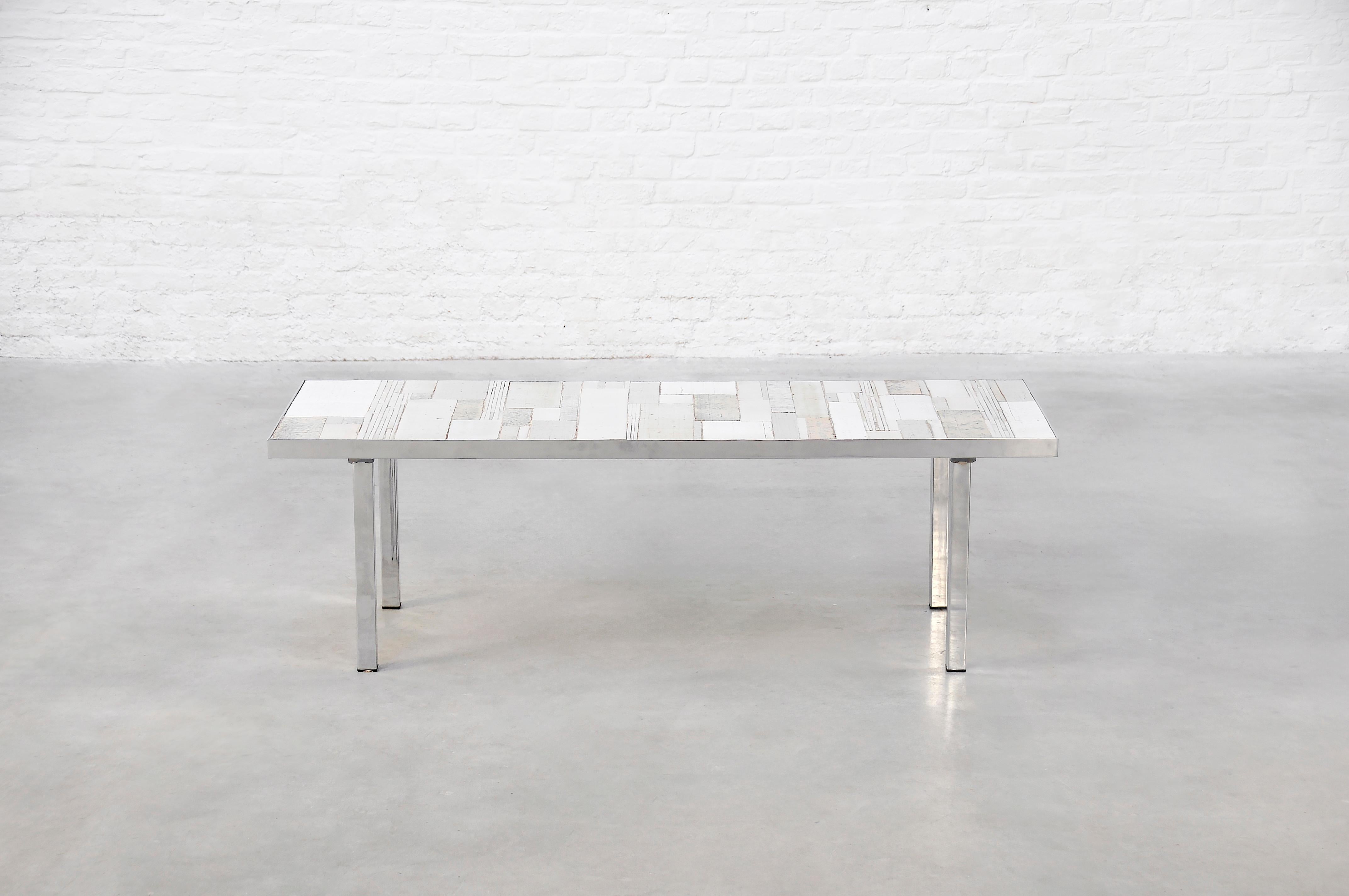 This exceptional coffee table, designed by renowned Belgian ceramist Rogier Vandeweghe and produced by Amphora in 1960s Bruges, exemplifies mid-century modern artistry. The table features a chrome-plated metal frame supporting a top inlaid with