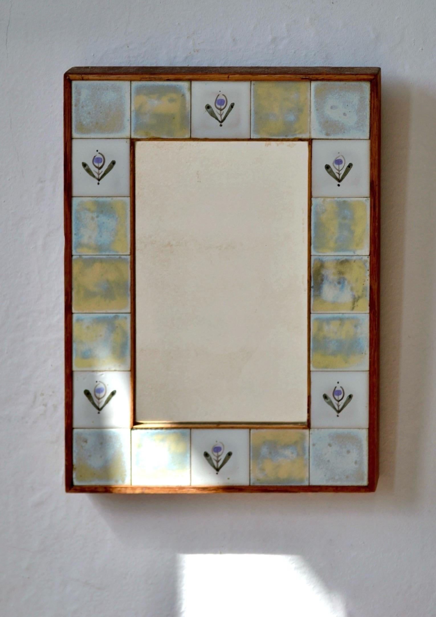 Espejo rectangular enmarcado con azulejos de cerámica esmaltada con motivos florales estilizados, en el espíritu de Vallauris. Atribuido al estilo de Roger Capron. Placa de espejo original con atractiva pátina. Lomo de madera.
Una pieza decorativa