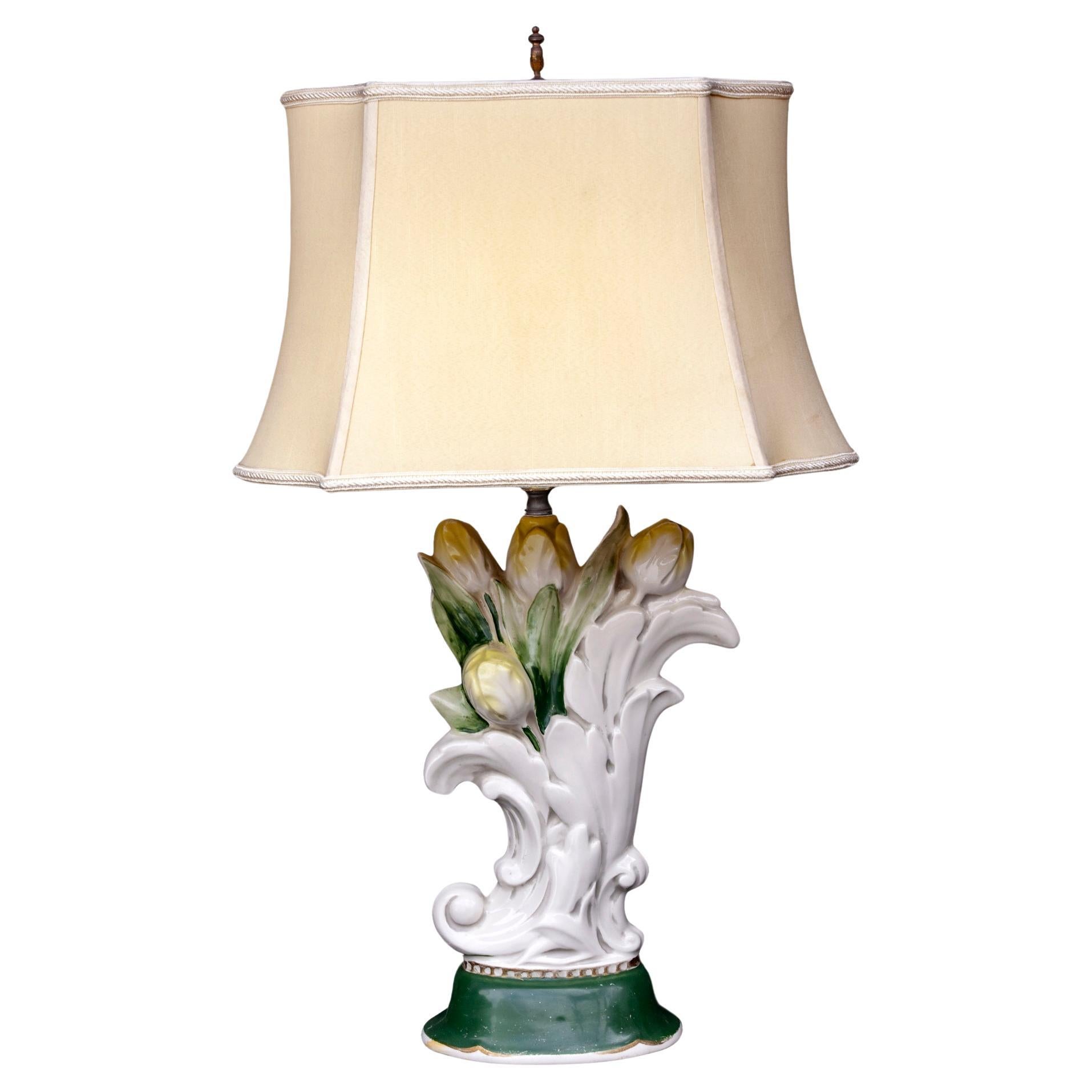 1940's Italian ceramic lamp with a cluster of flowering tulips with a pastel yellow glaze. The ombre leaves surround the tulips in an ornate white vessel which sits on a green base with a beaded rim. The bottom of the base is trimmed in gild over