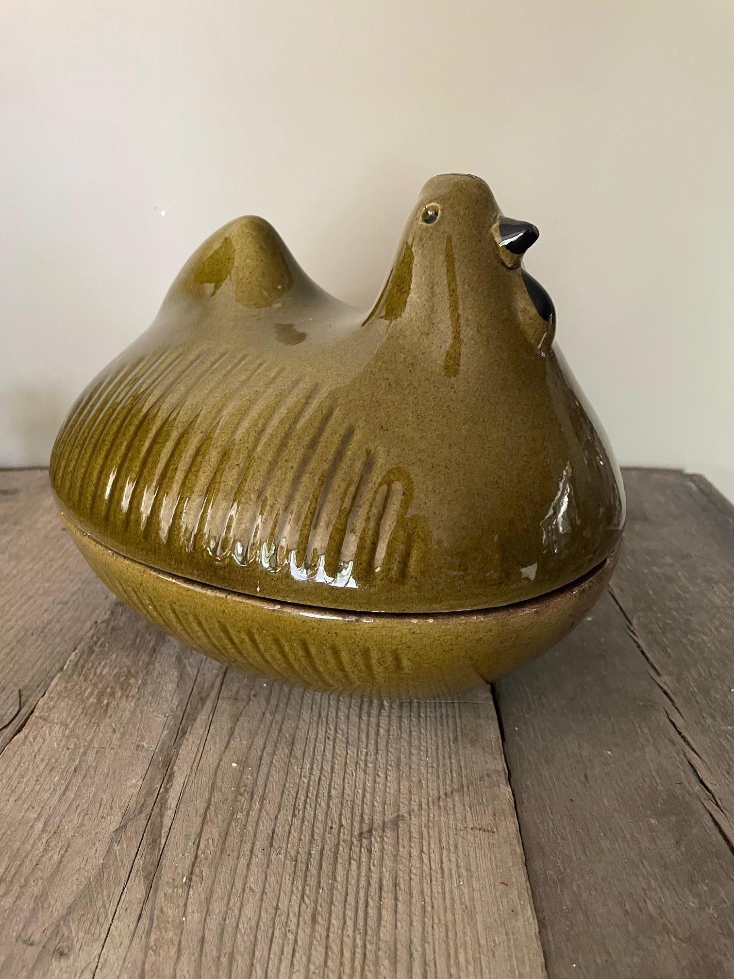 This ceramic tureen is shaped like a hen and was used to store onions, shallots or garlic in the kitchen. Its olive green colour is very appealing.