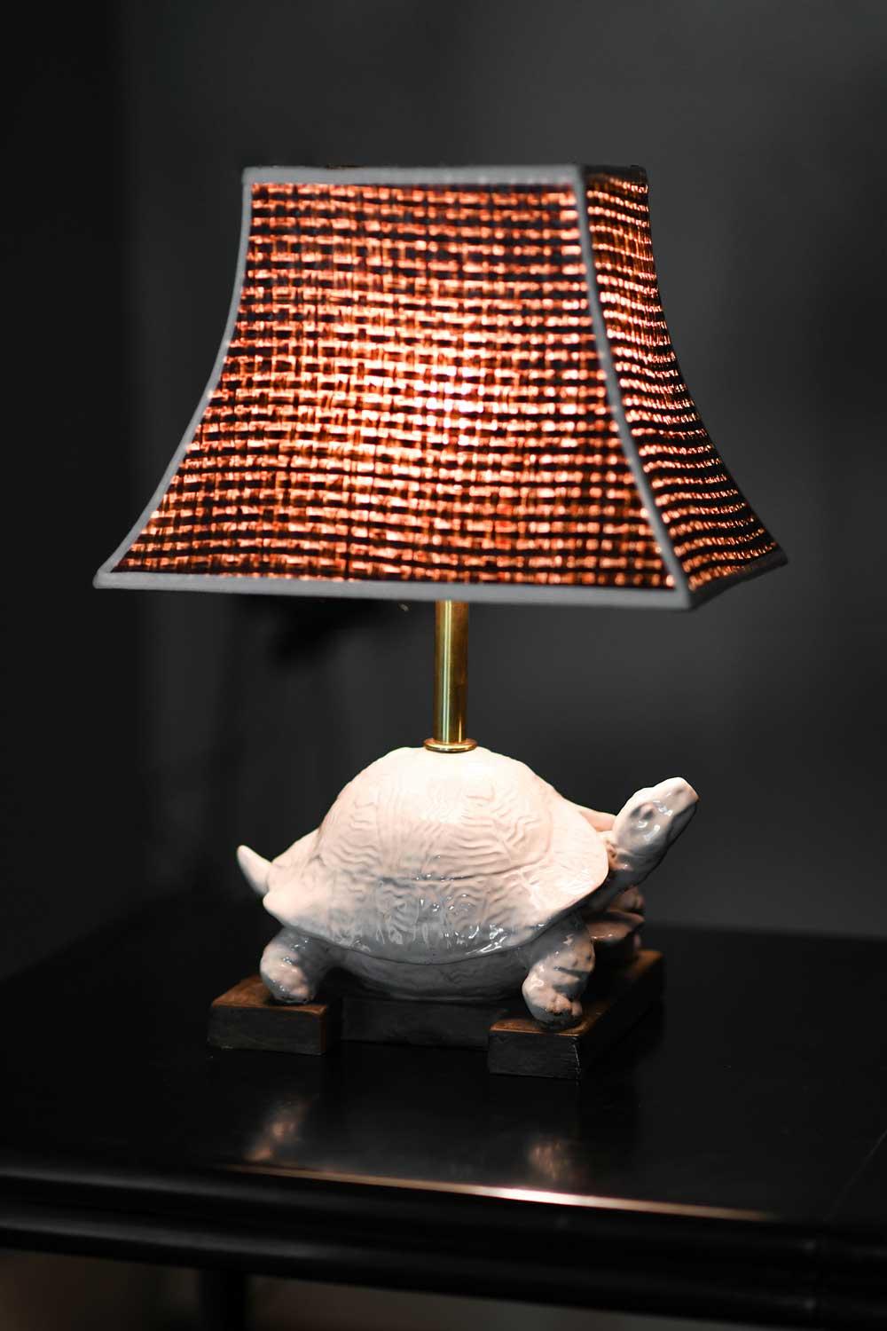 Turtle shaped table lamp in white glazed ceramic. 
Designed by Ugo Zaccagnini, 1970s. 
Complete with straw lampshade and wooden base.