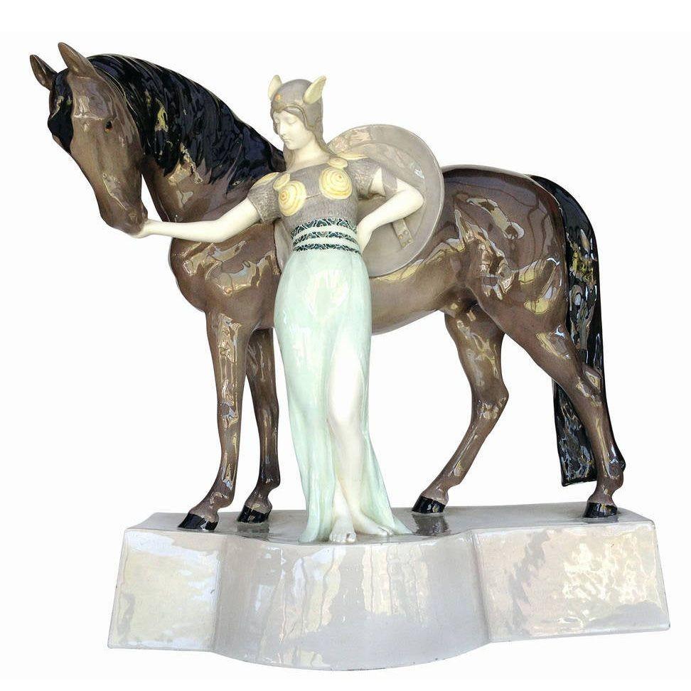 Designed by artist Stanislaus Capeque for Goldschnider, circa 1930, the sculpture presents a traditional Valkyrie from Norse mythology in armor and shield with her trusty horse standing beside her. The statue features a graceful form and beautiful