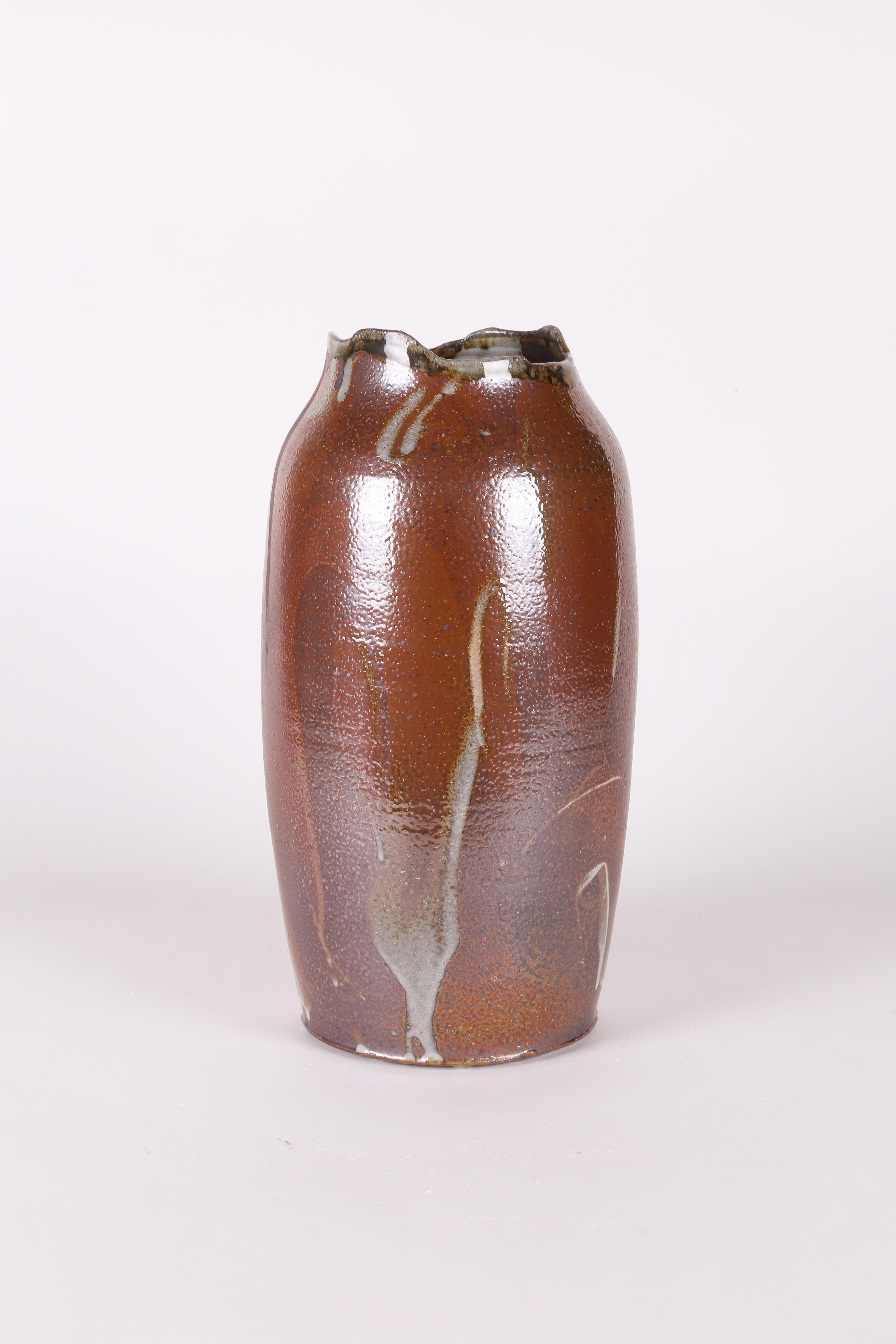 Vase aus handgedrehtem und im Holzofen gebranntem Steinzeug mit einer reich gesättigten ockerroten Glasur mit ausdrucksstarken, gestischen Schlieren in tiefbraunen und rostfarbenen Erdtönen. Dieses einzigartige Gefäß wurde im Studio der bekannten