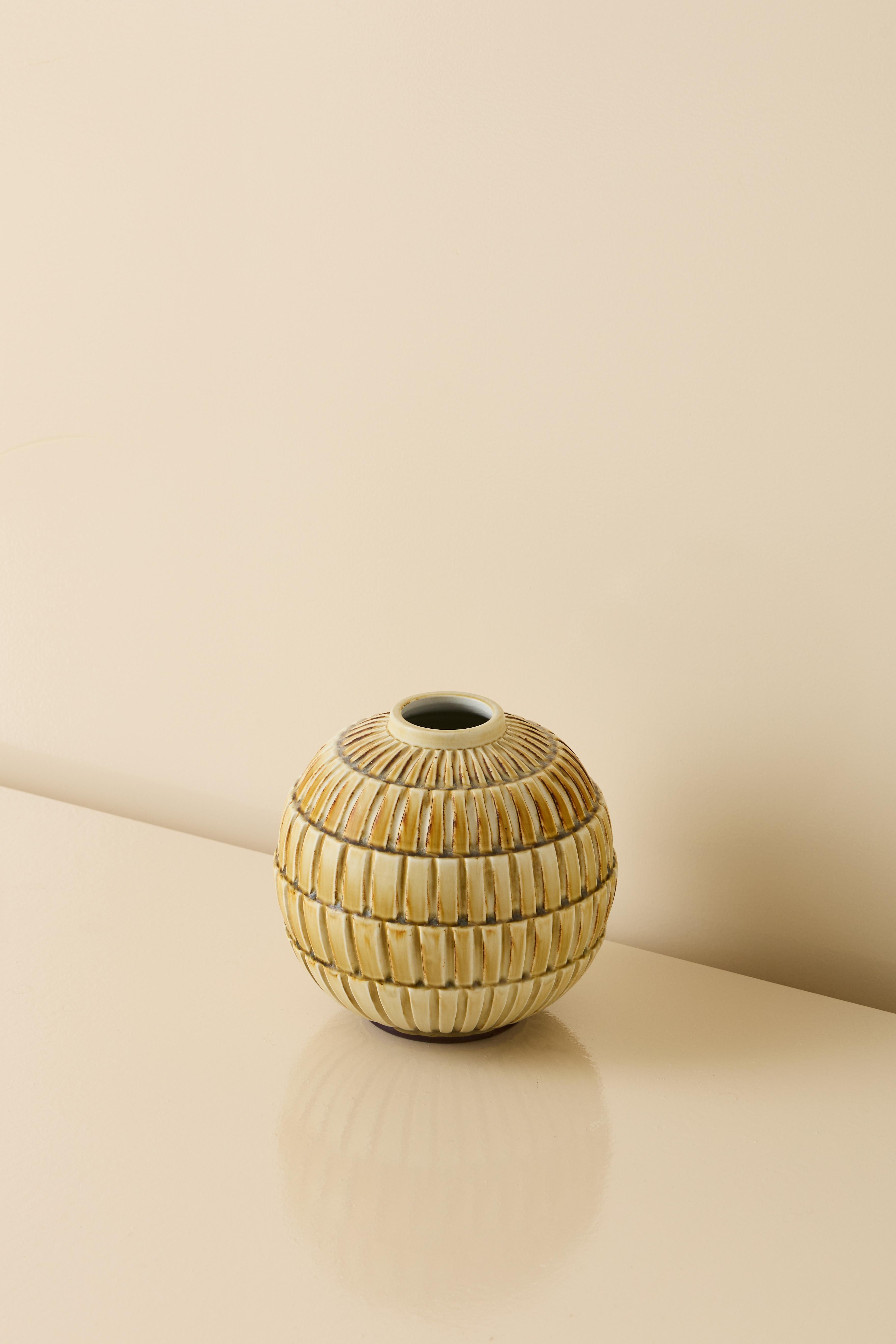 Ceramic vase by Gertrud Lonegren in golden glaze and a highly textured surface. 

Measures: Diameter 21 cm
Height 21.5 cm

Lonegren studied in Vienna and Stockholm during the 1920s, she worked at Upsala-Ekeby in the 1930s before creating these