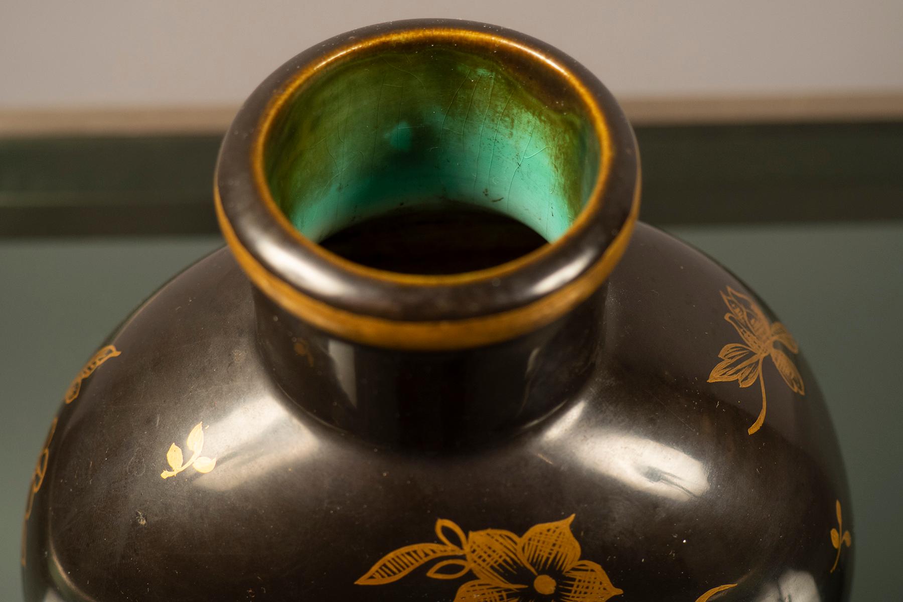 Schwarze Keramikvase mit kleiner Öffnung und handgemalten goldenen Blumenmotiven. Signiert am Sockel.