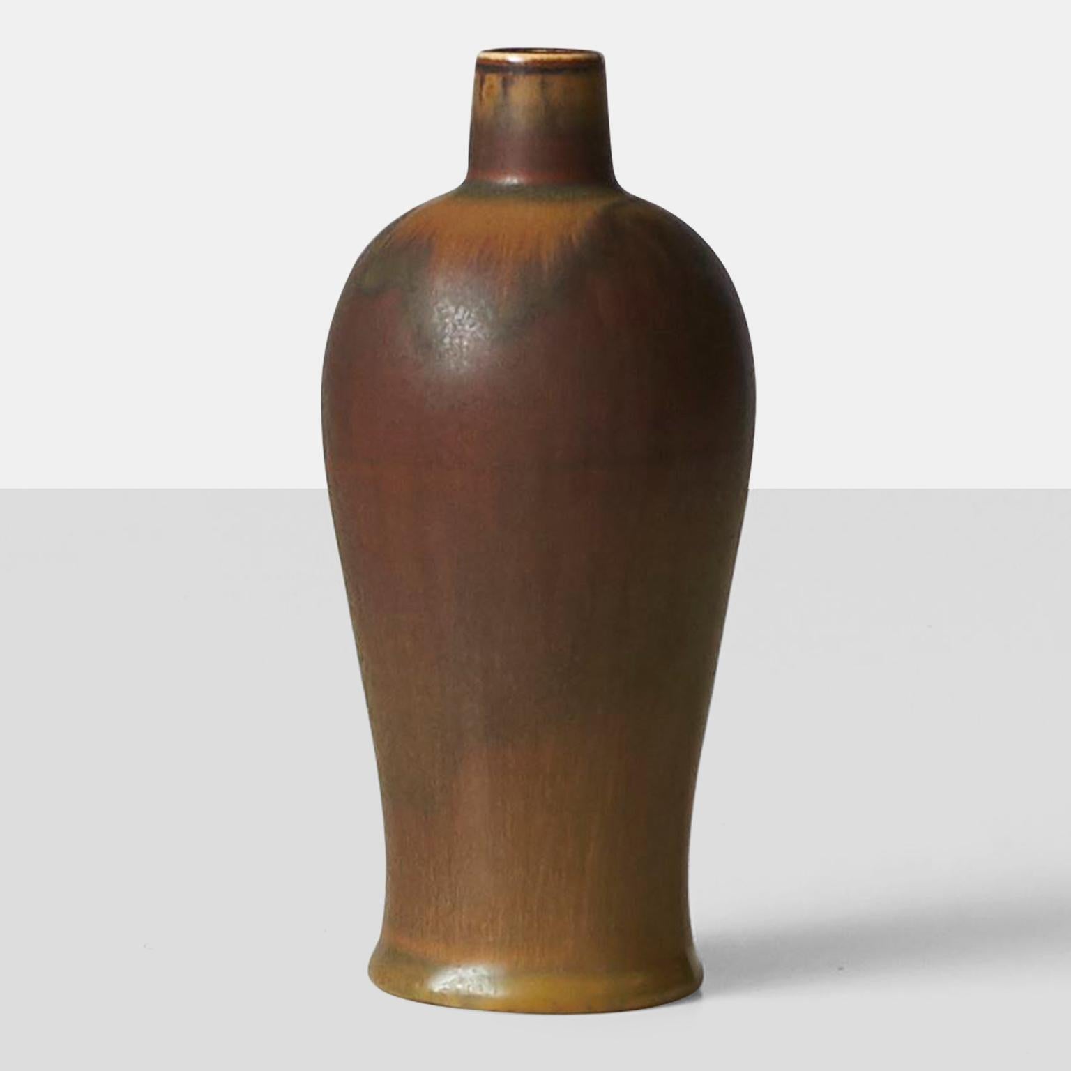 A ceramic vase by Swedish designer Gunnar Nylund. Glazed in a palette of earth tones, the vase is signed Nylund and marked Rorstrand on the base.