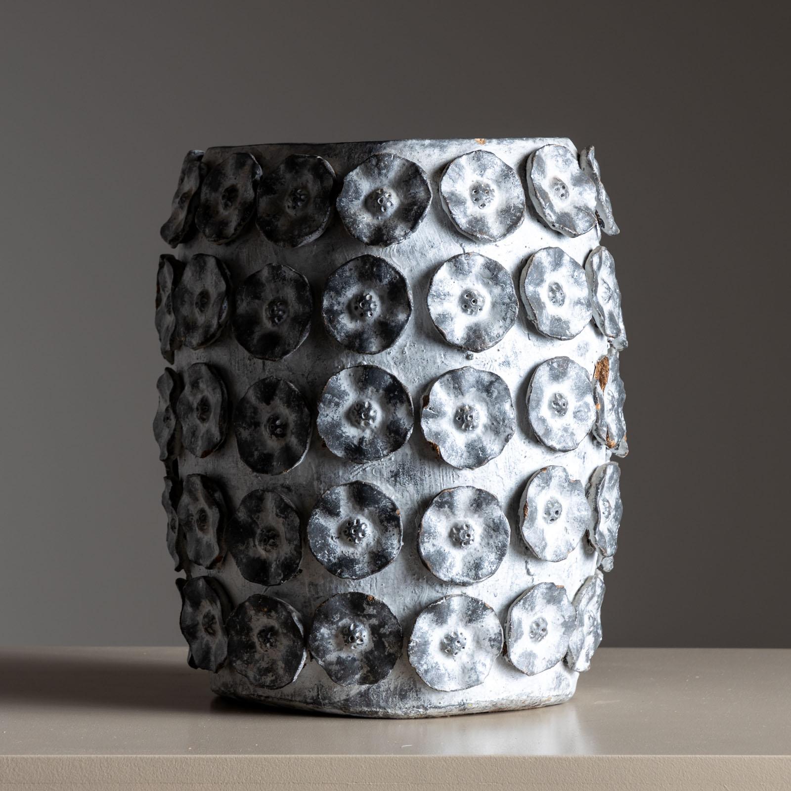 Vaso in ceramica italiana della metà del secolo scorso dalla forma rotonda e leggermente bulbosa, ornato da foglie e fiori applicati sulla superficie. Smaltato in bianco con uno sfondo marrone che traspare, questo vaso reca il timbro 
